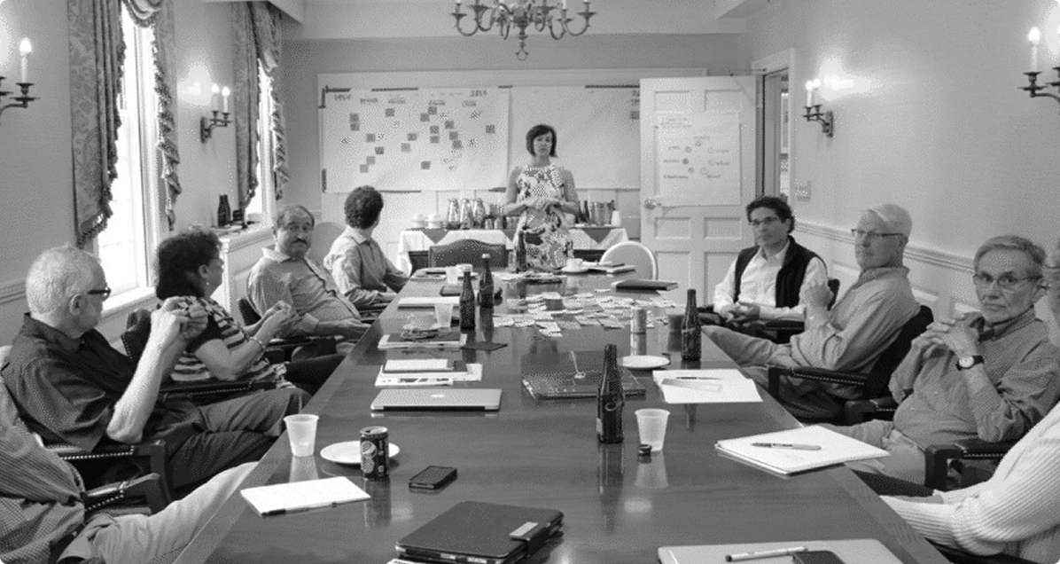 TRU2U meeting with participants seated around a table, engaged in discussion.