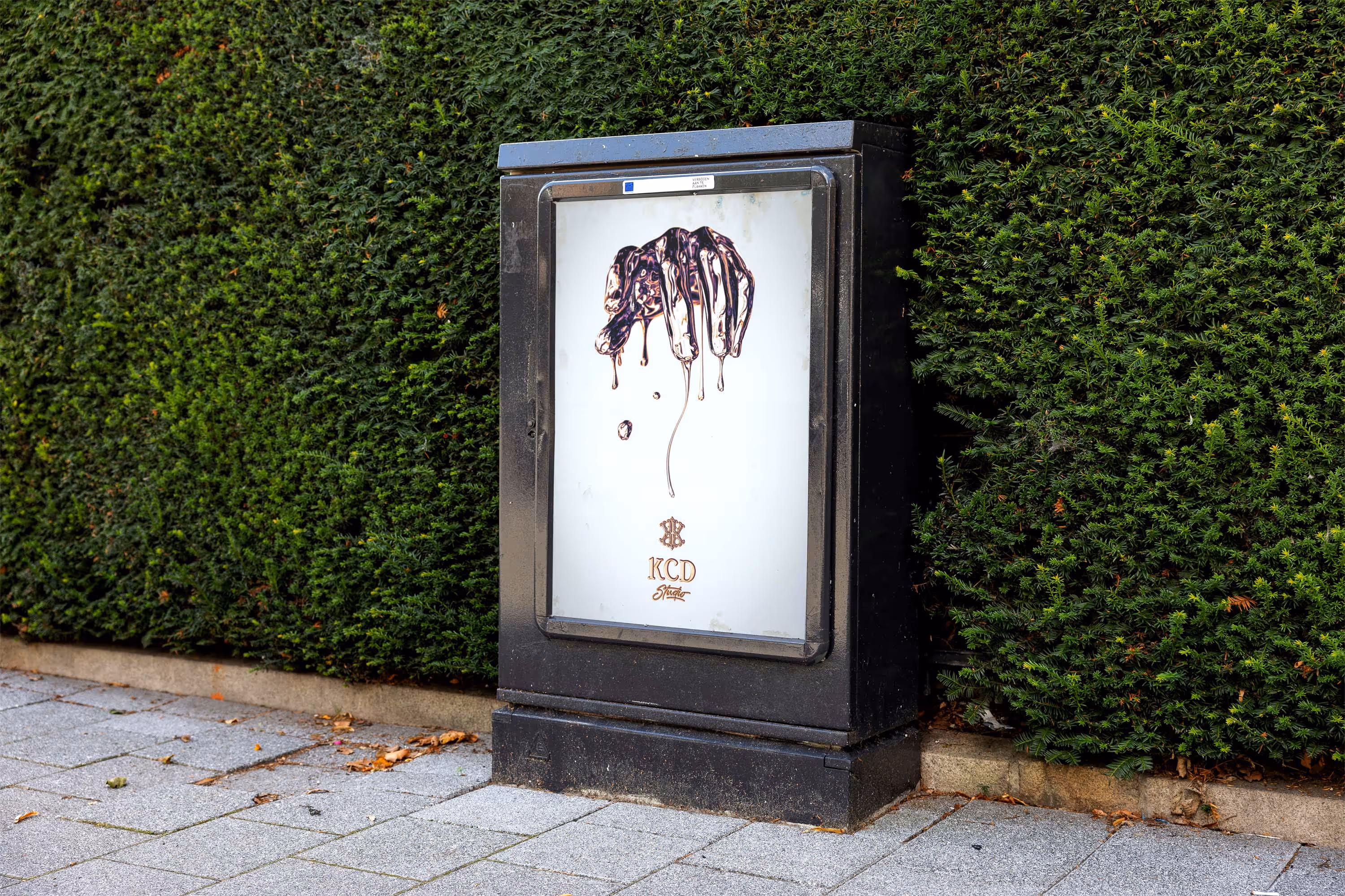 street display box in front of hedge