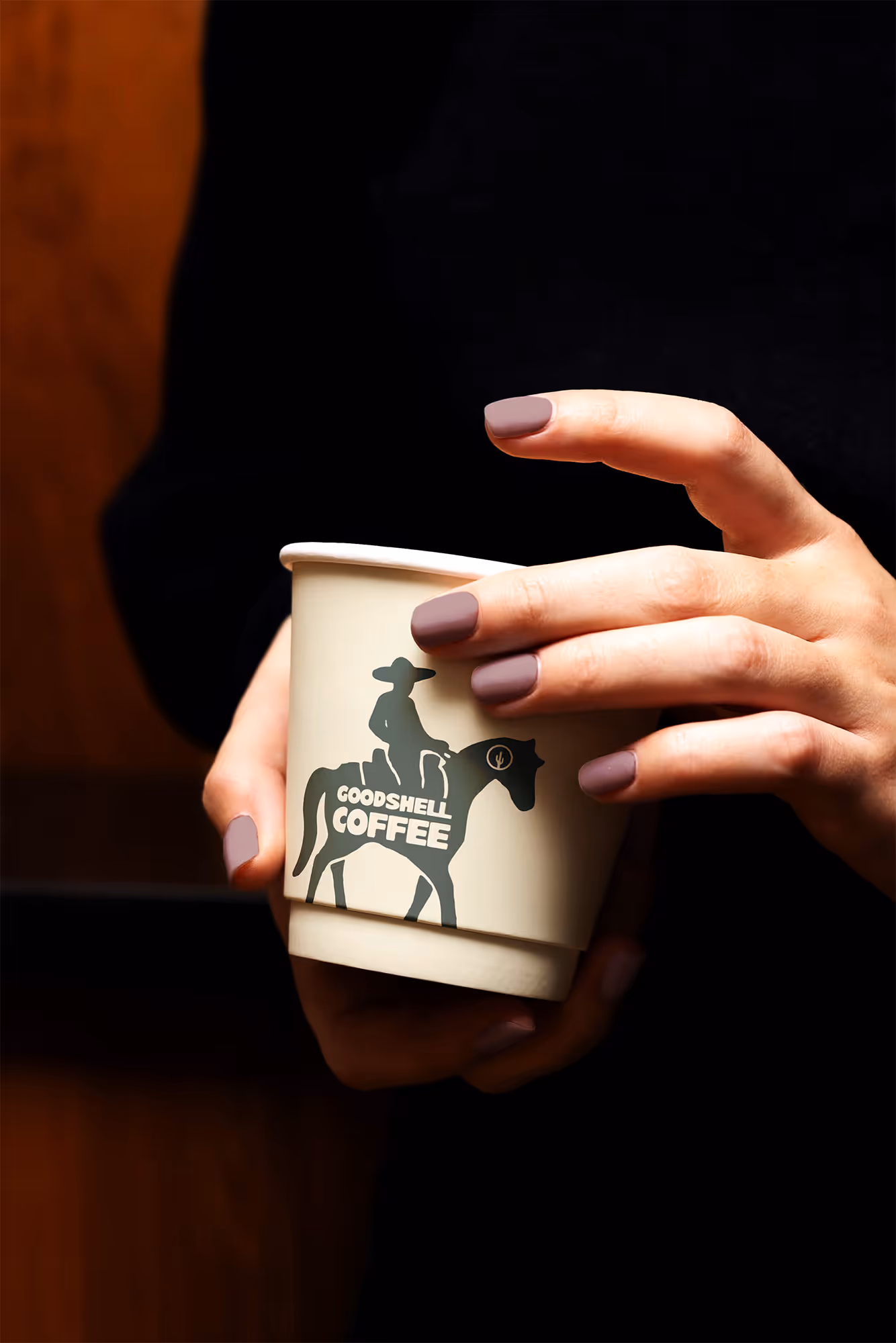 woman holding branded paper coffee cup