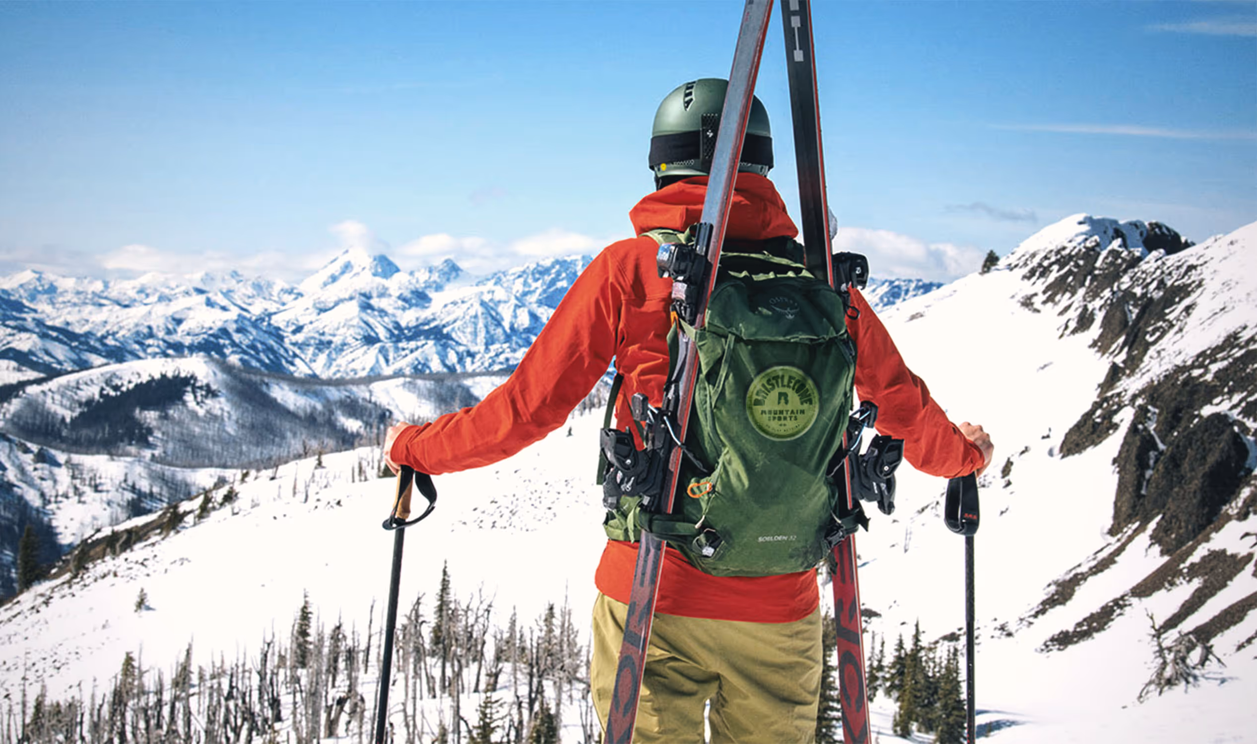 Skiier looking out over mountains with backpack
