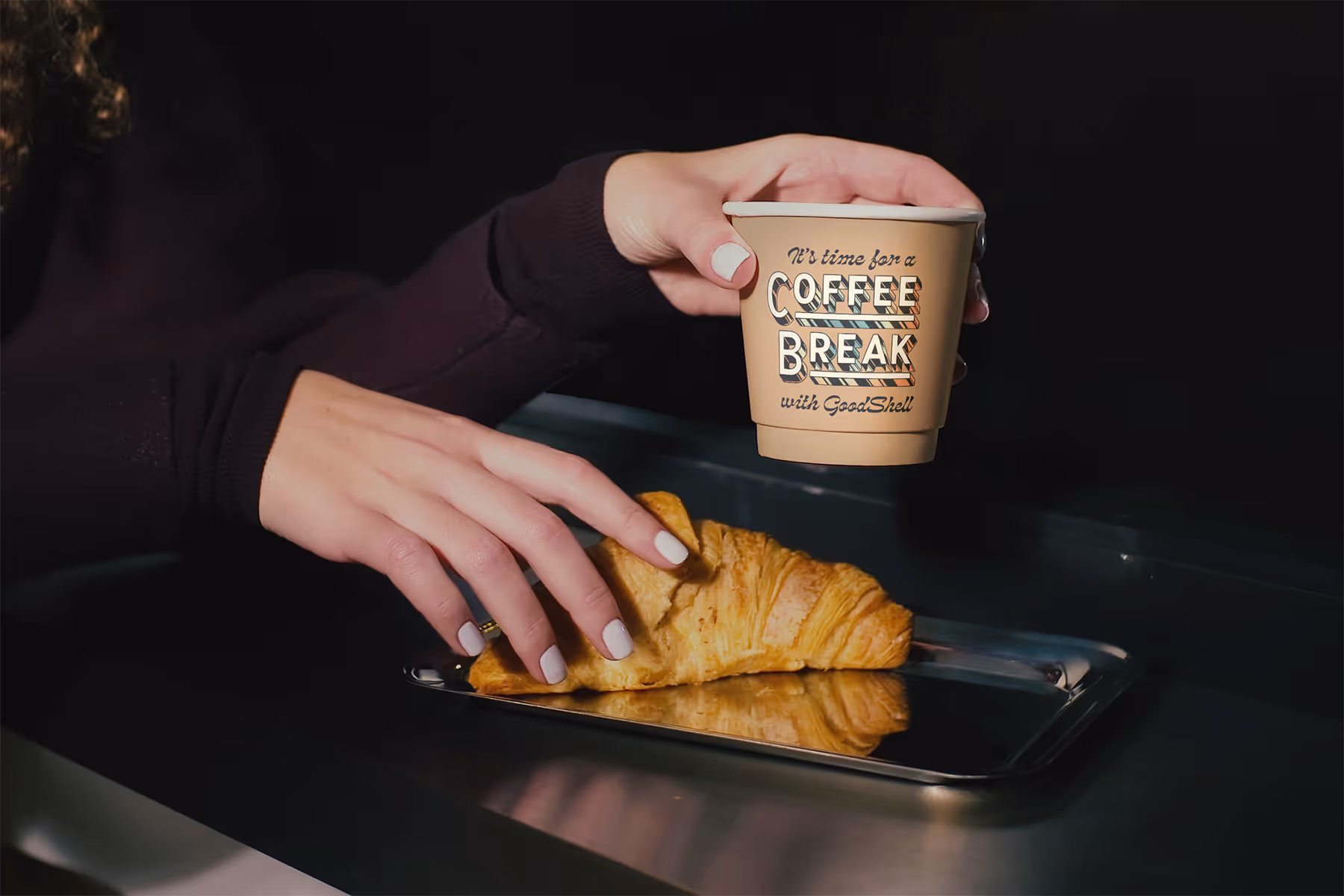 woman holding coffee cup with pastry