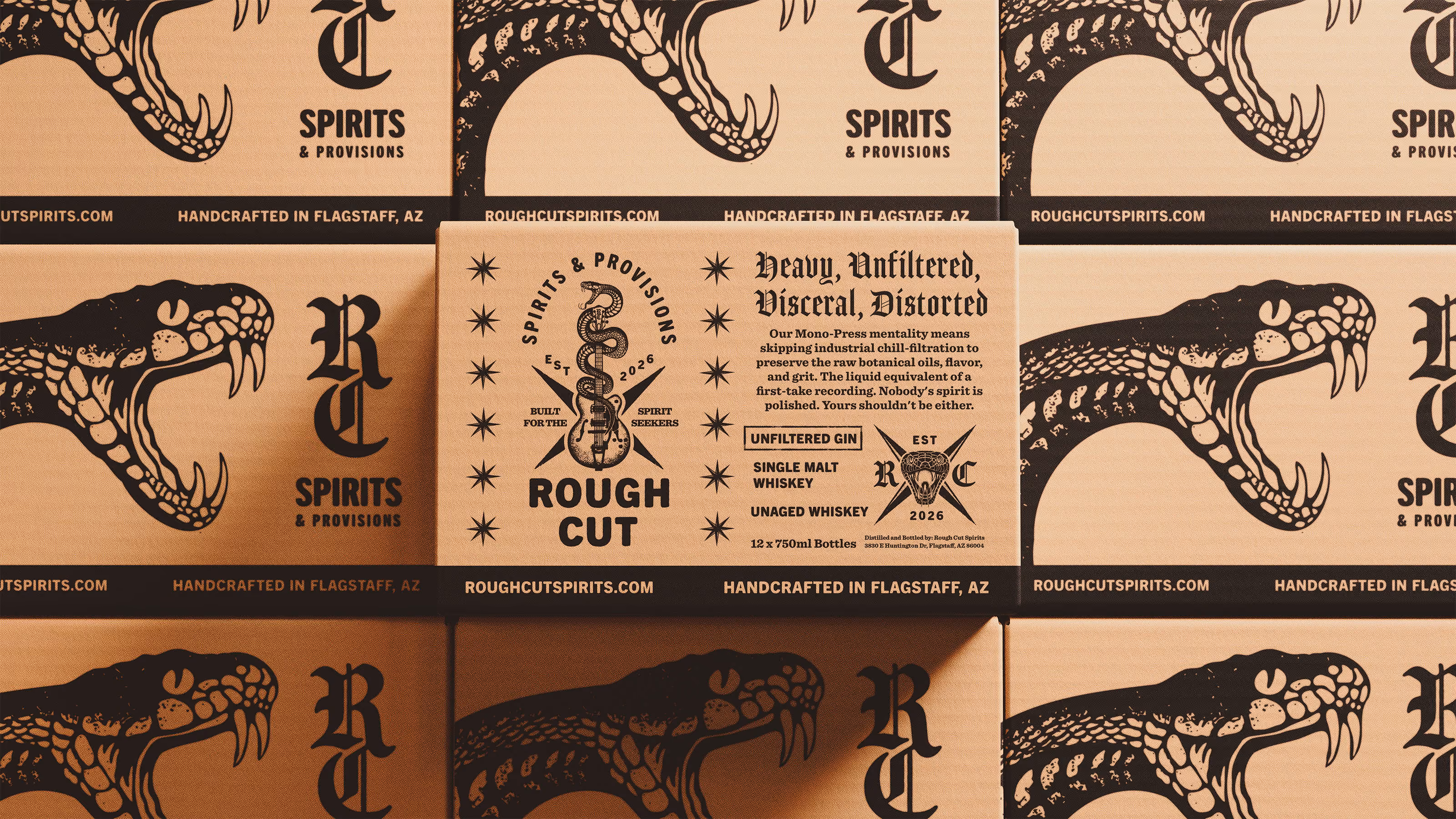 Stacks of Rough Cut box packaging featuring a bold black snake head graphic and text highlighting handcrafted spirits and provisions from Flagstaff, AZ, with one box showing detailed product information including 'Heavy, Unfiltered, Visceral, Distorted,' types of whiskey, and establishment year 2026.