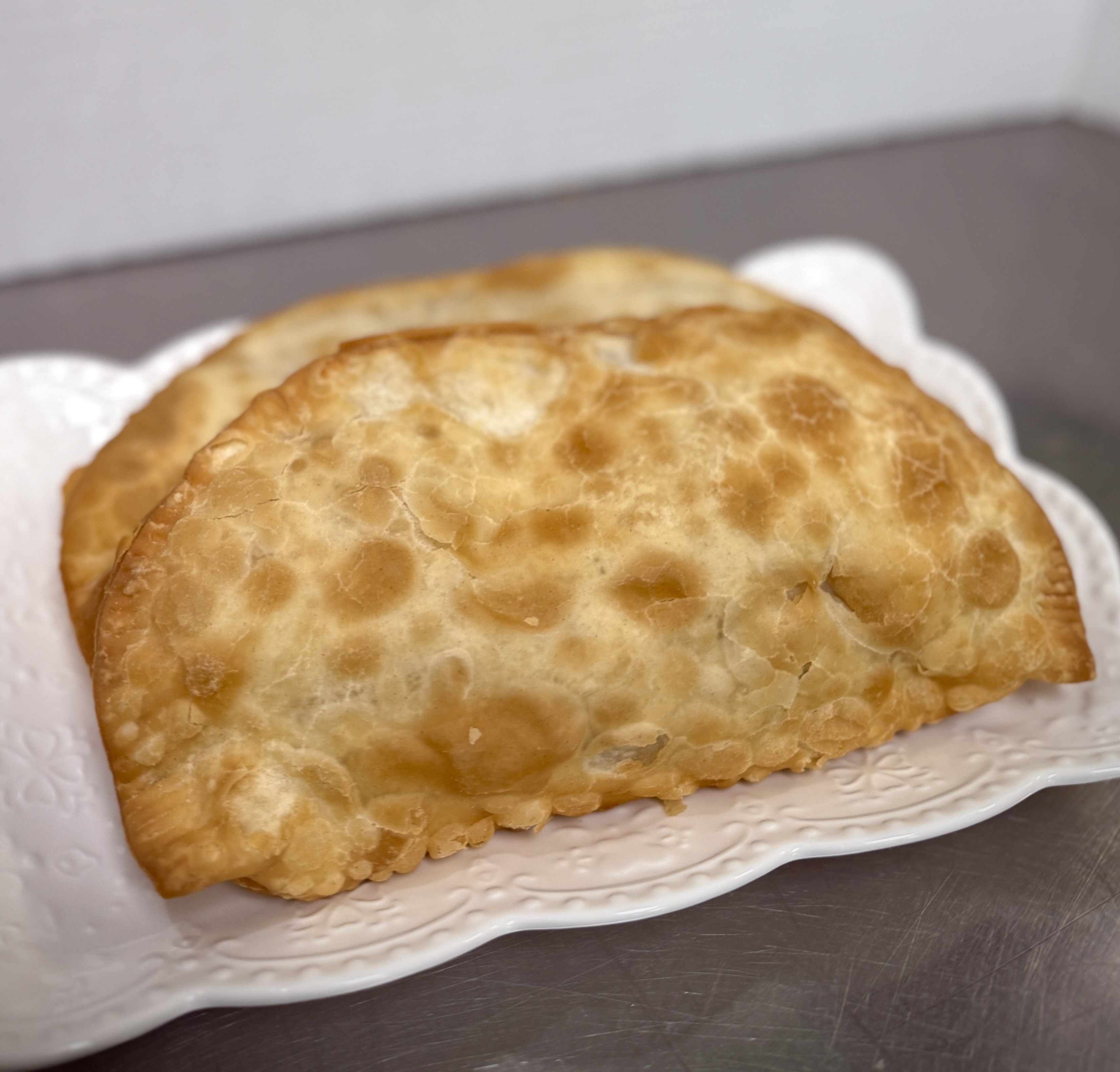 Burger with fried fries on black plate with sauce on the side