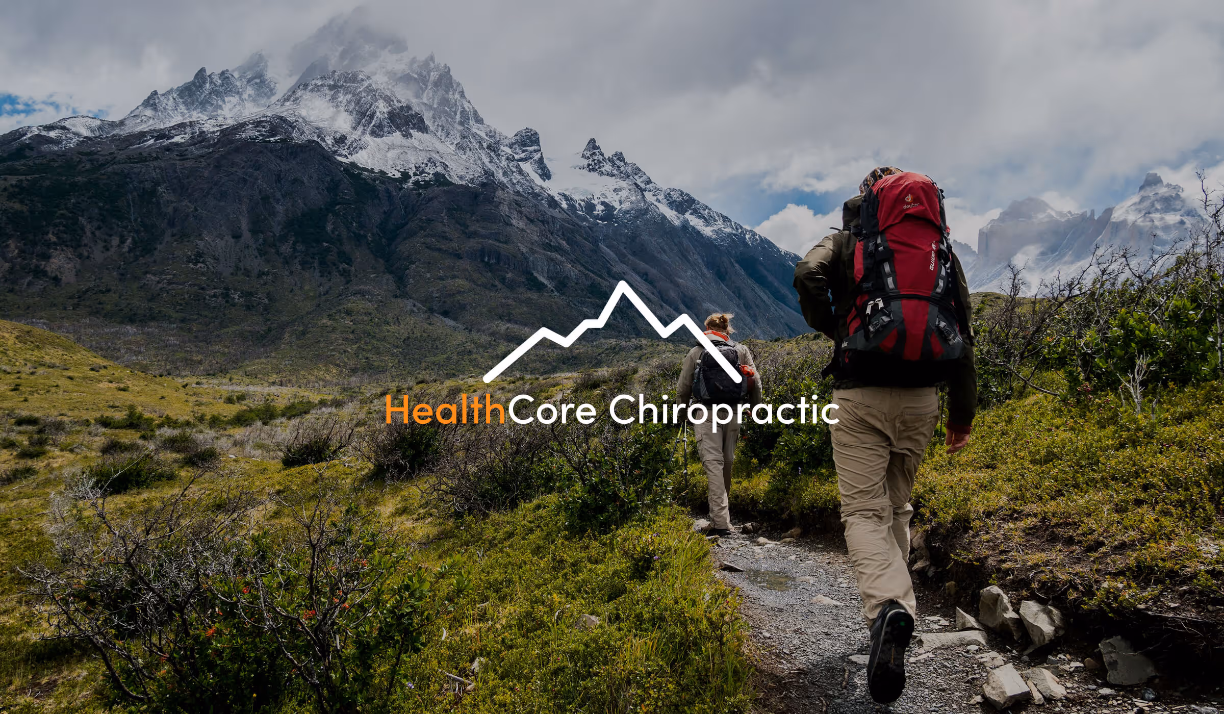 Two hikers walking up a mountain with the HealthCore Chiropractic & Rehab logo centered