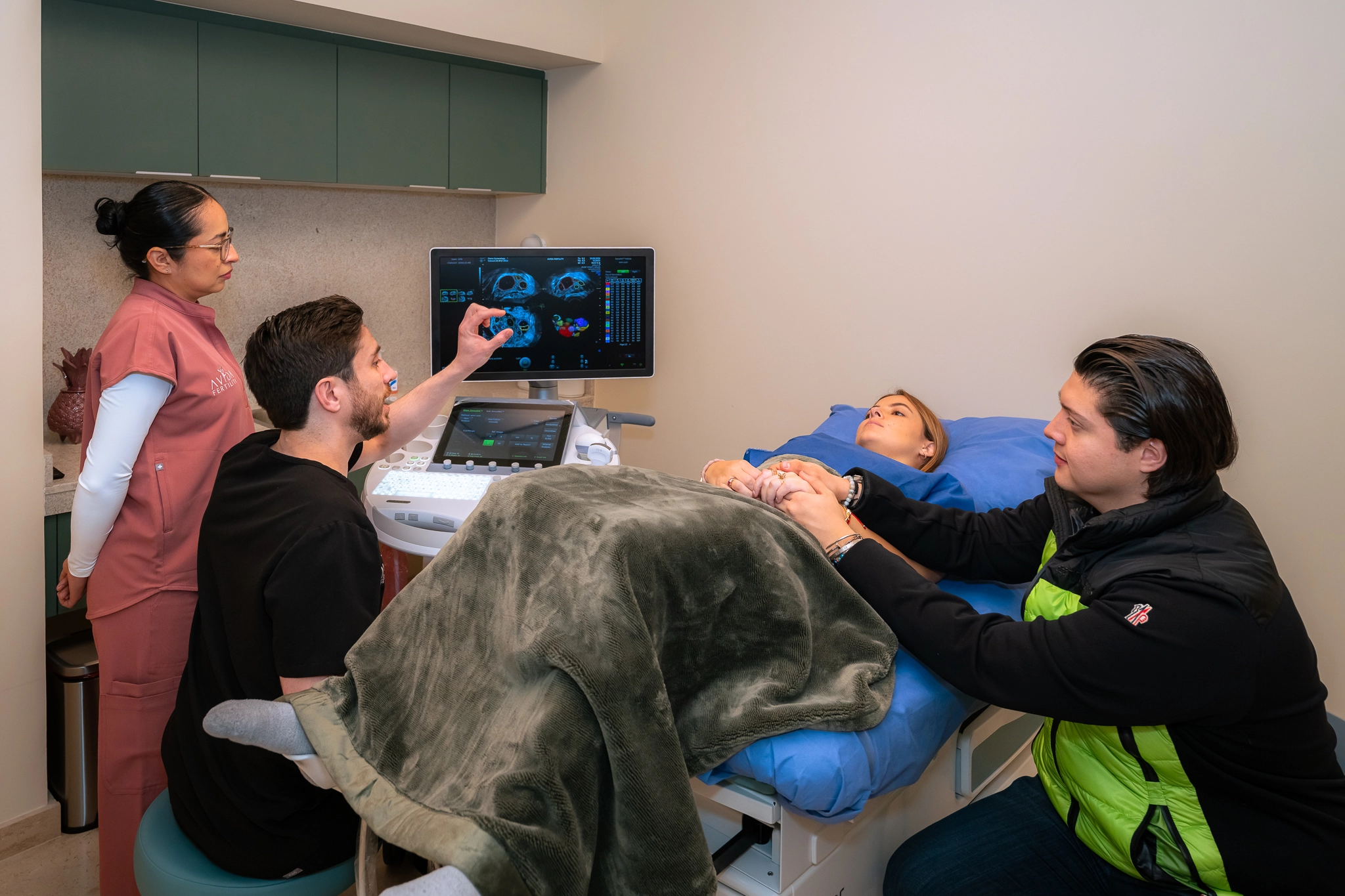Equipo médico de Avida Fertility realizando un ultrasonido a una paciente acompañada de su pareja