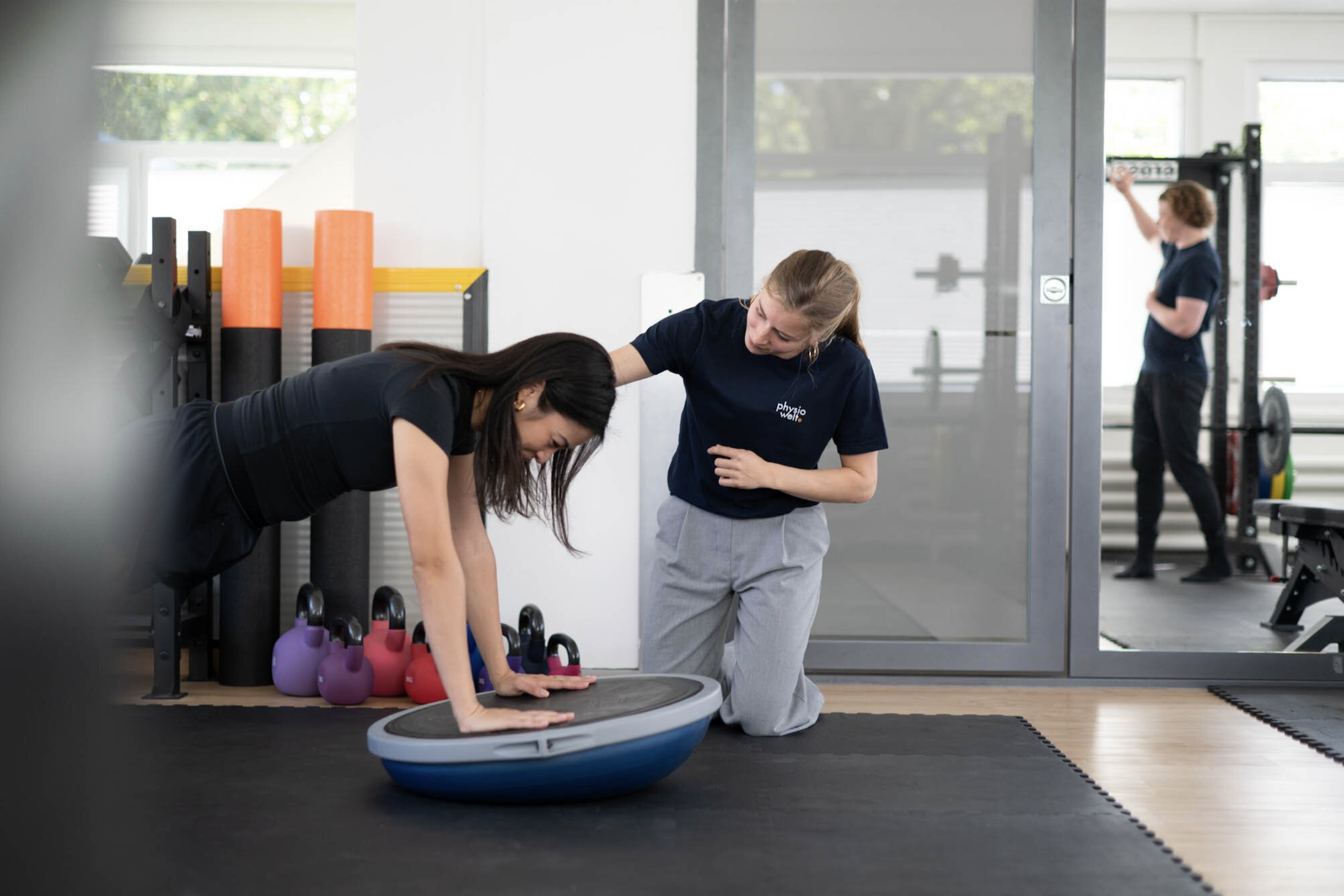 Physiotherapeutin betreut Patientin beim Stabilitätstraining im Rahmen der Sportphysiotherapie.
