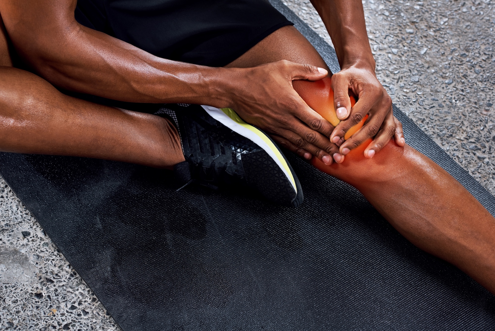 Sportler mit Knieschmerzen nach Belastung als Beispiel für eine Sportverletzung mit Rehabilitationsbedarf