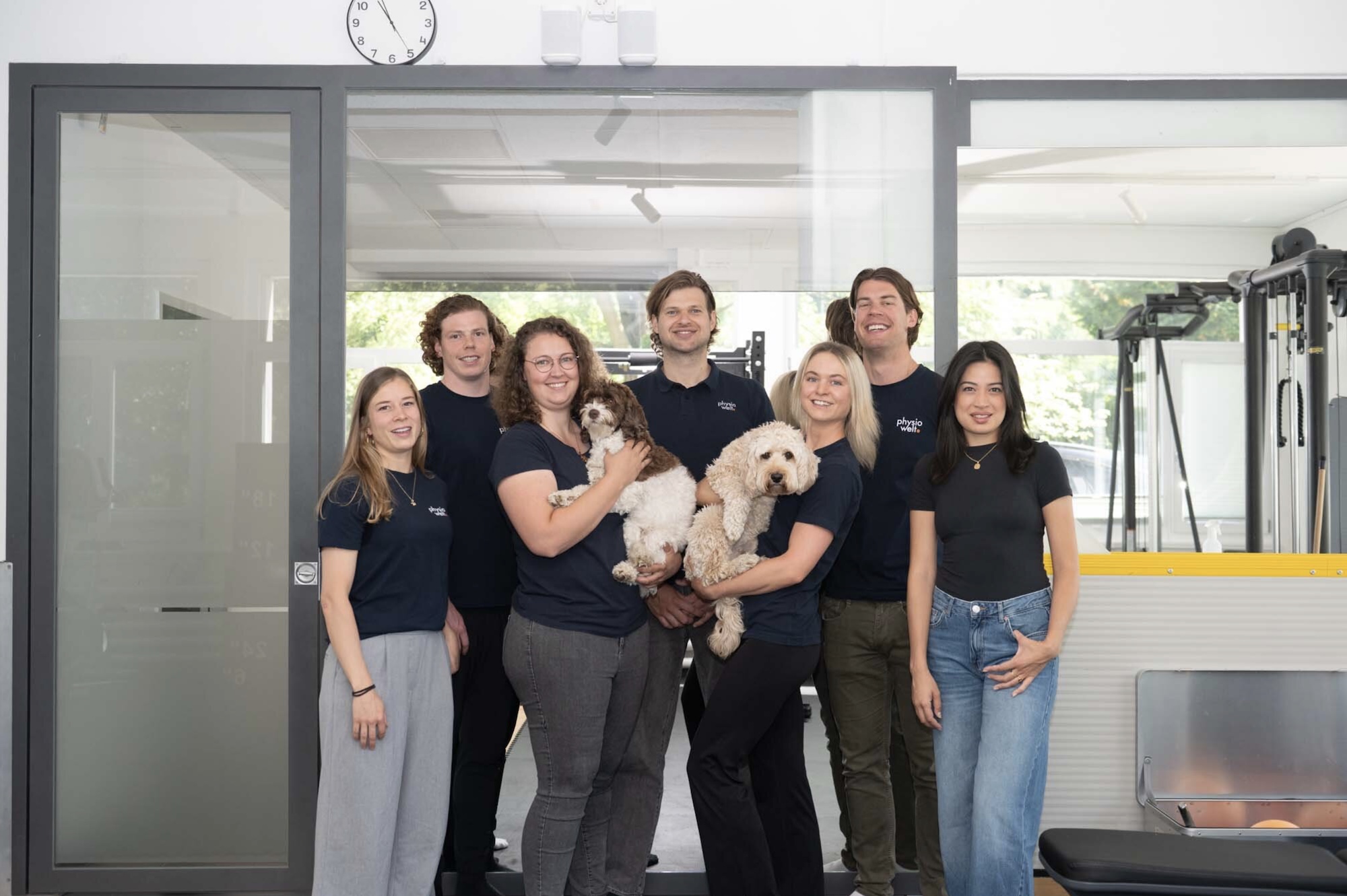 Team der Physiotherapie-Praxis PhysioWelt Zürich steht gemeinsam in den Praxisräumen.