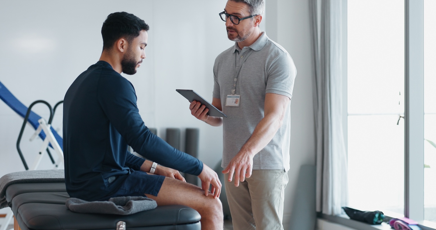 Physiotherapeut bespricht mit einem Patienten die funktionelle Beurteilung des Knies vor der Rückkehr zum Sport.