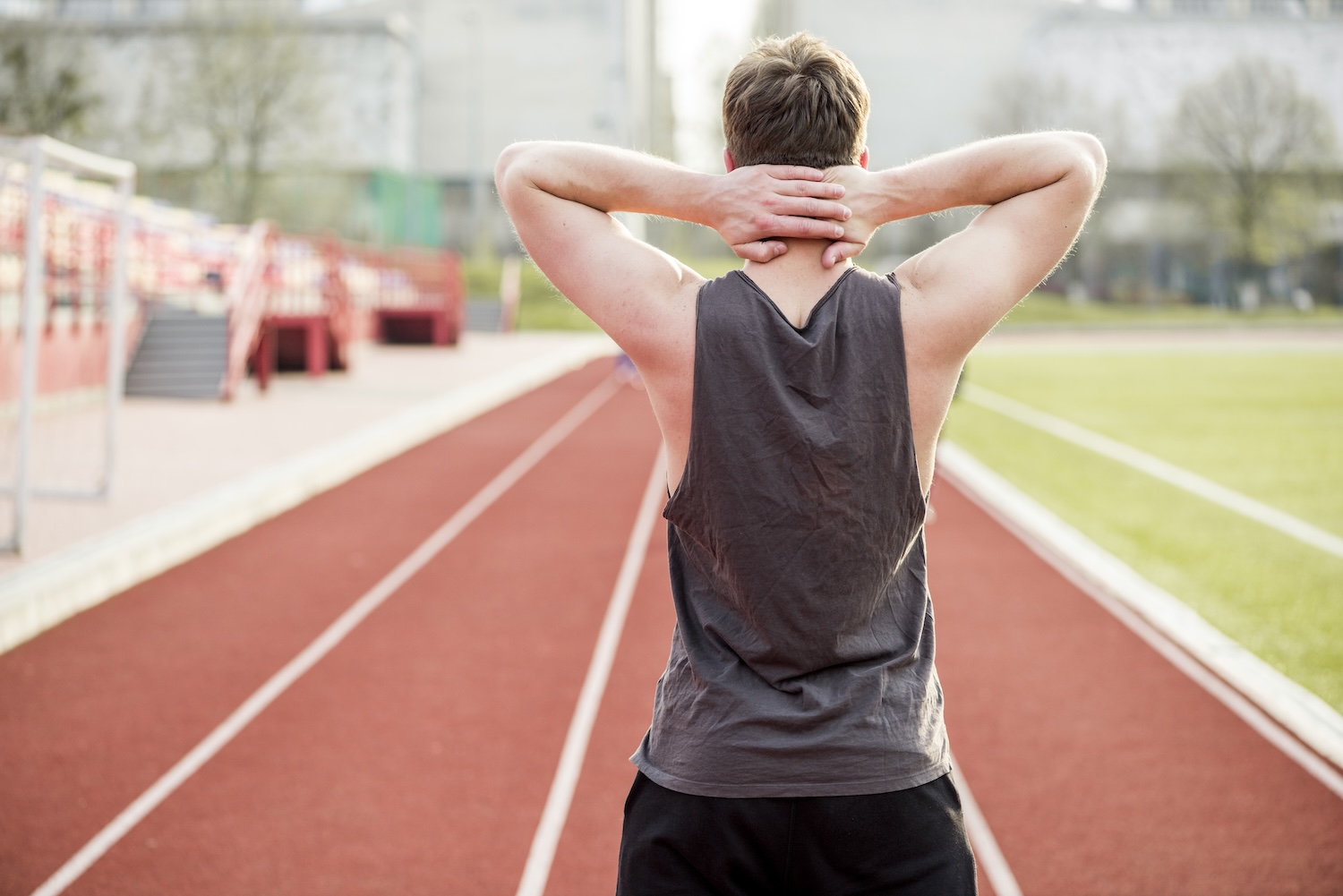 An athlete on a running track prepares for return to sport after an injury.