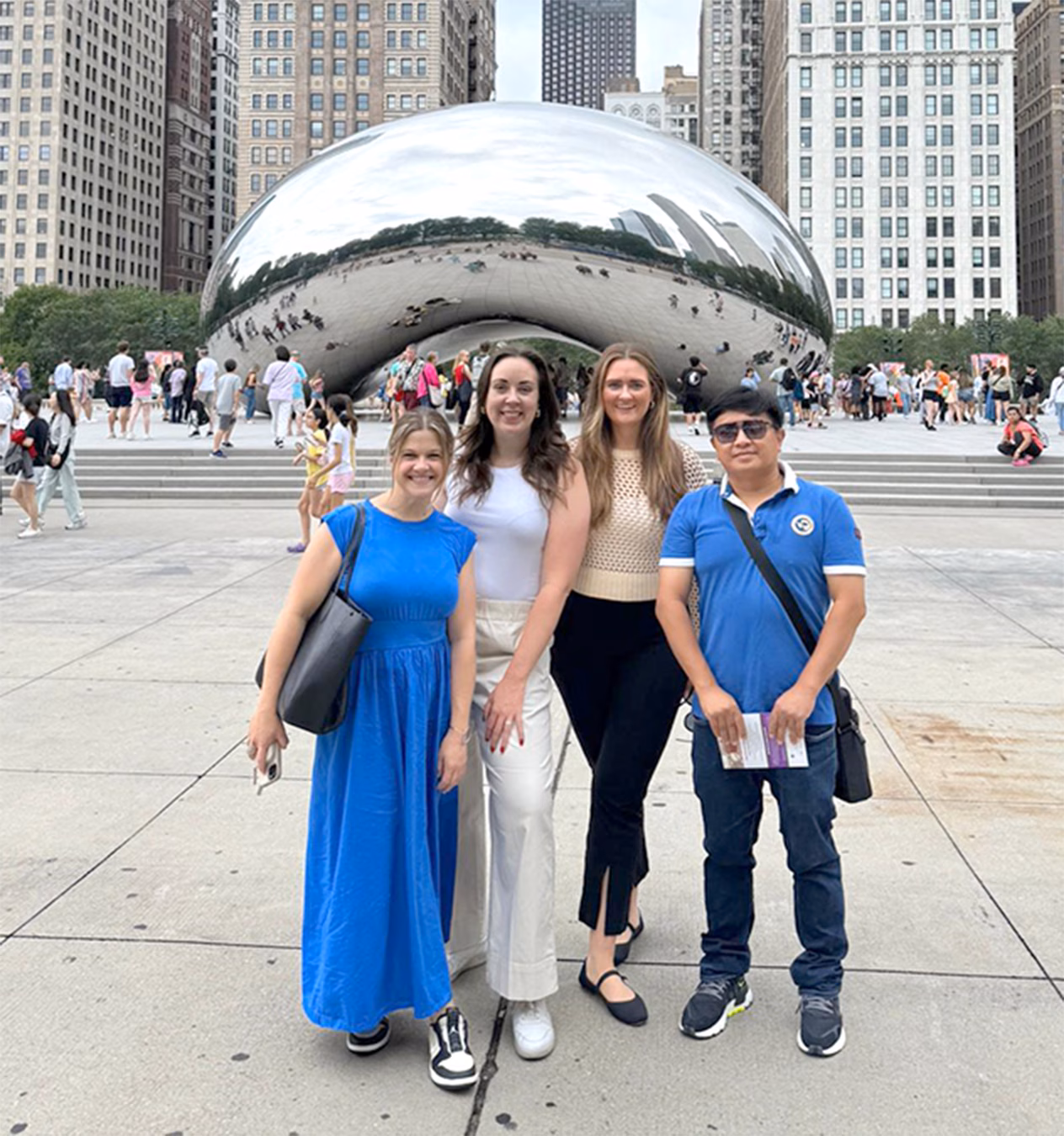 Three women and a man standing 
