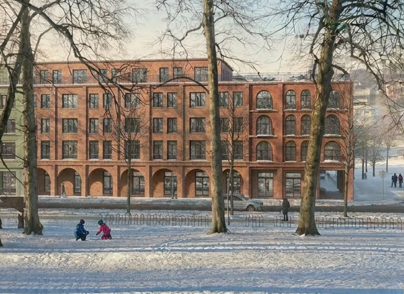 Vintersene med barn som leker i parken og murstensbygg i bakgrunnen