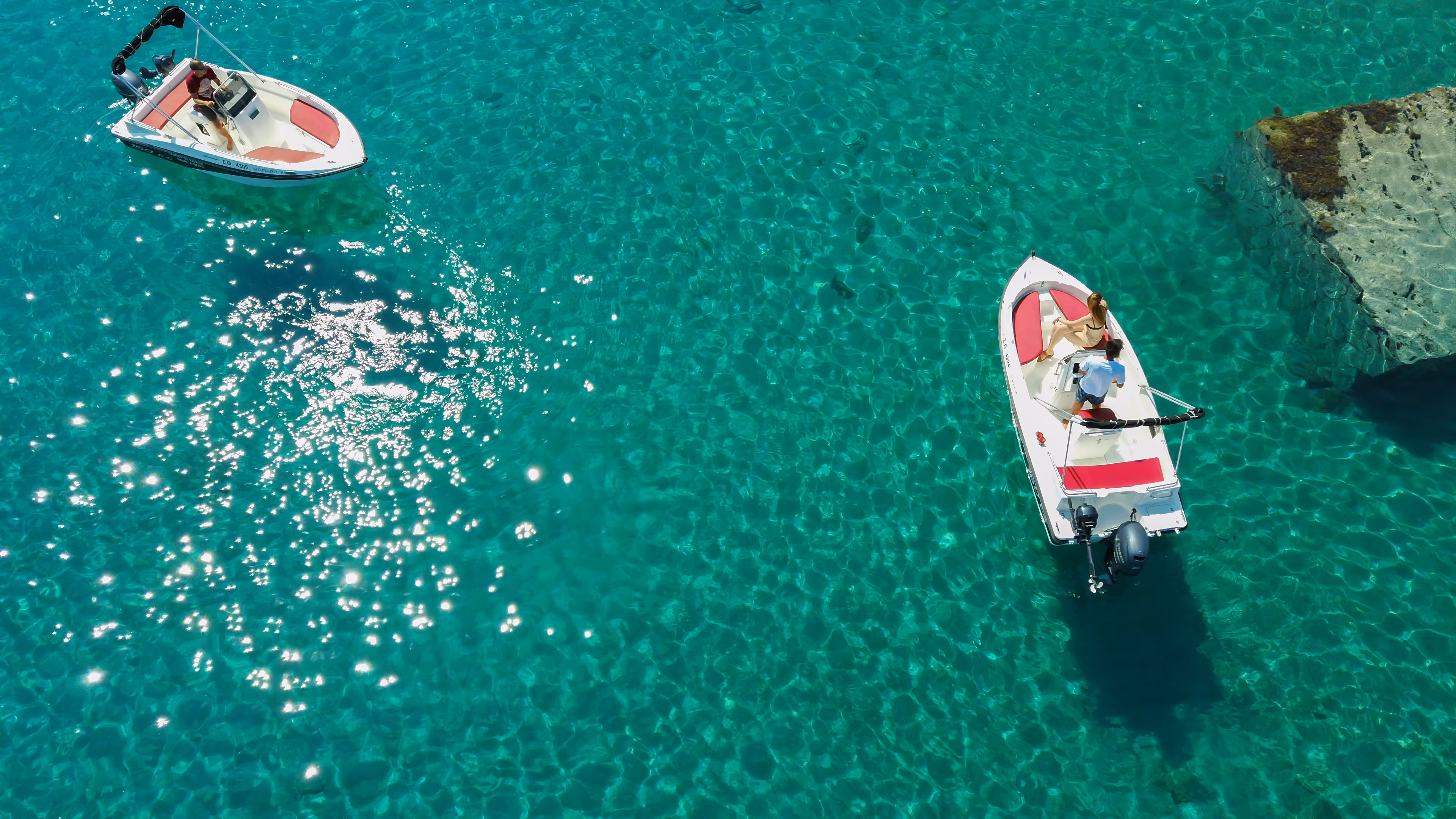 aerial-shot-people-driving-motorboats-transparent-sea 2