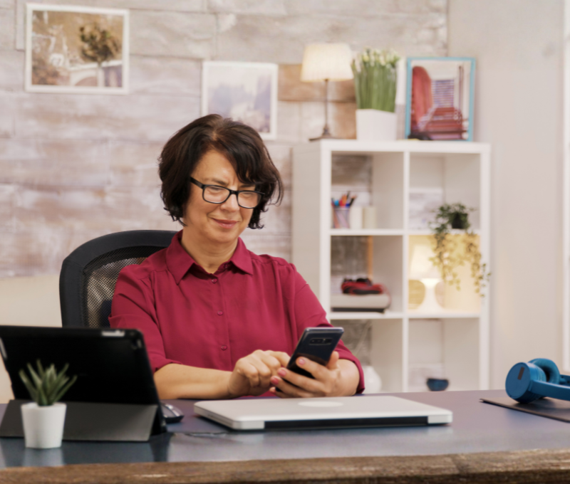 Woman holding phone at desk