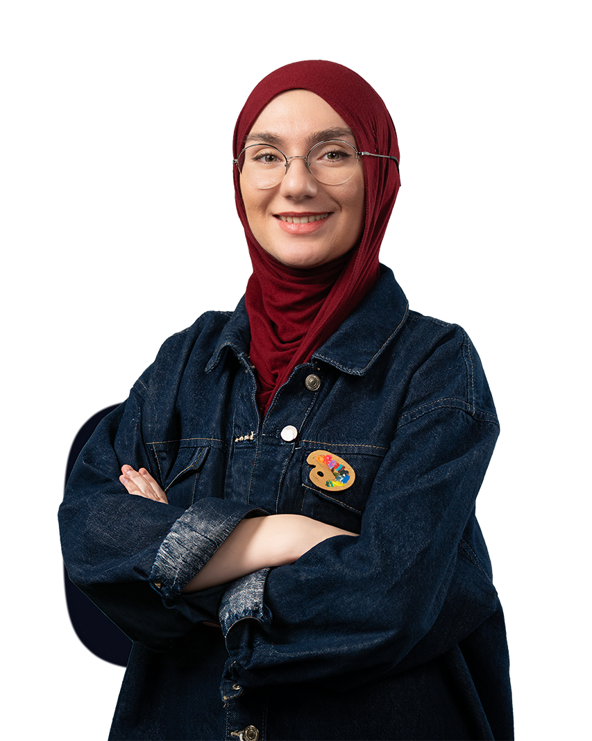 Woman wearing a red hijab, glasses, and a dark denim jacket with an artist palette pin, smiling with arms crossed.