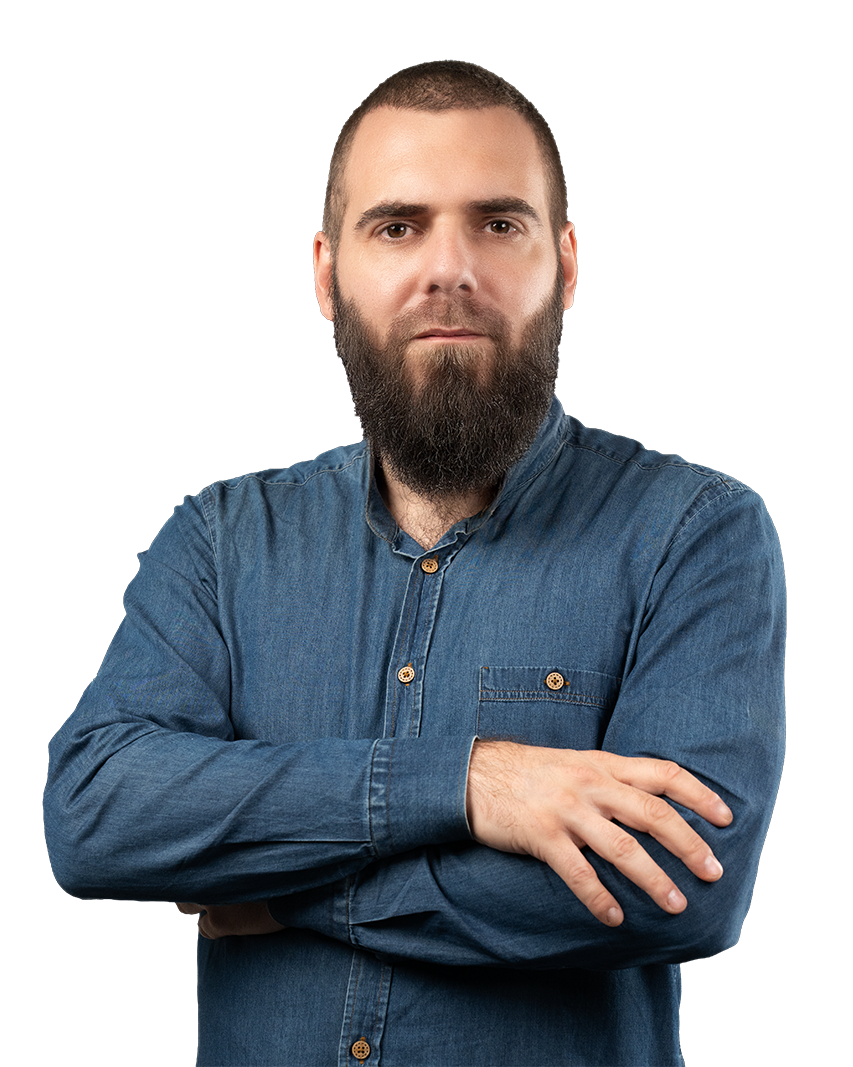 Bearded man in a blue denim shirt with arms crossed, facing forward.