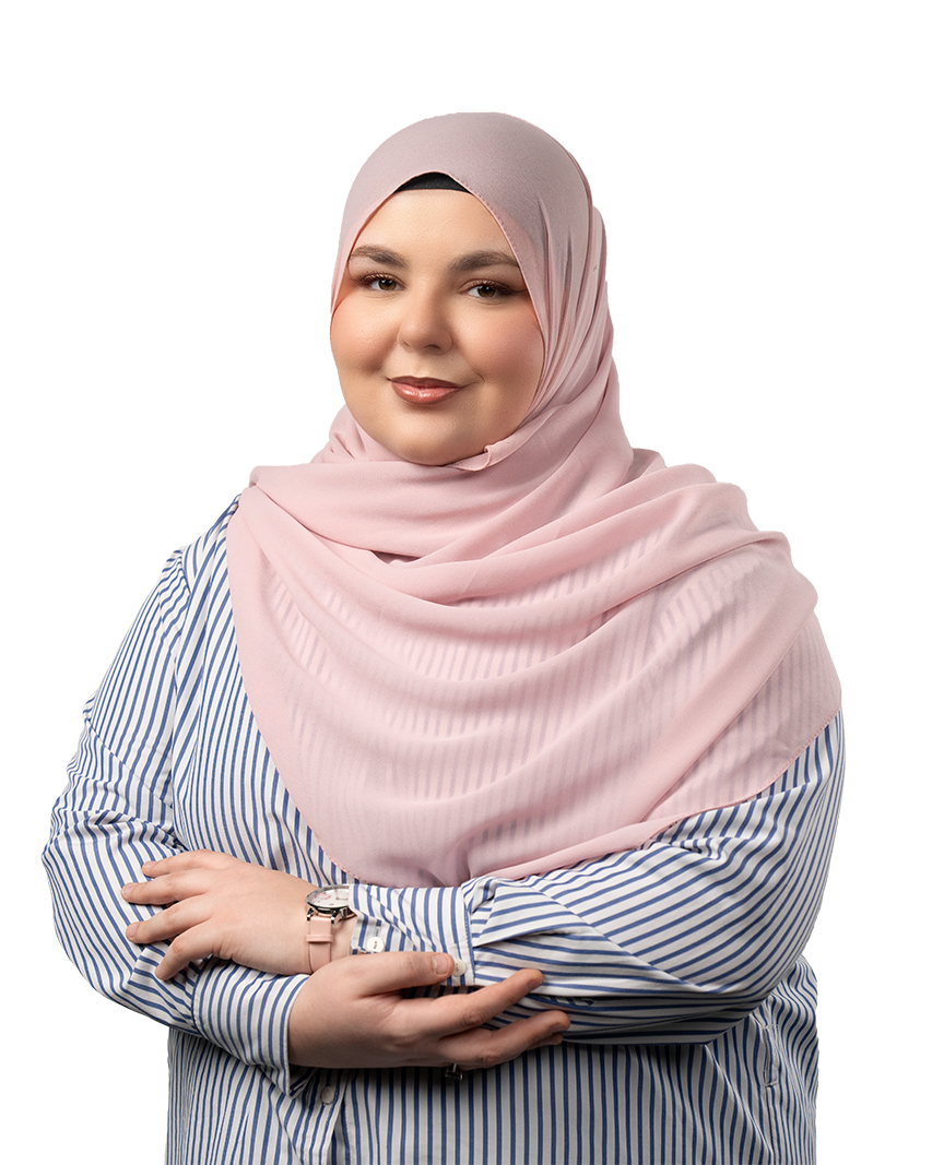 Smiling woman wearing a pink hijab and blue-and-white striped shirt with arms crossed.