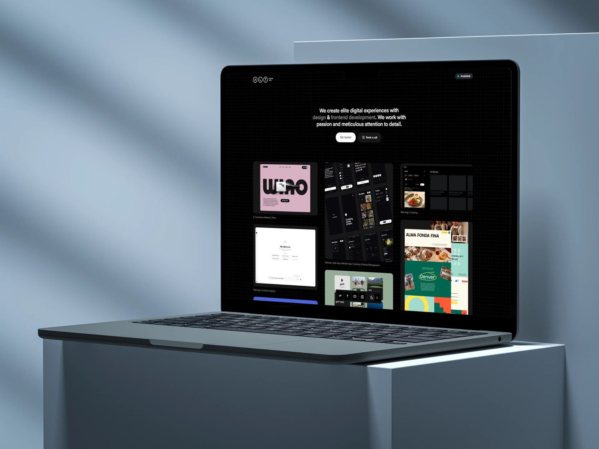 A laptop on a table displays a website on its screen, showcasing a modern workspace setup.