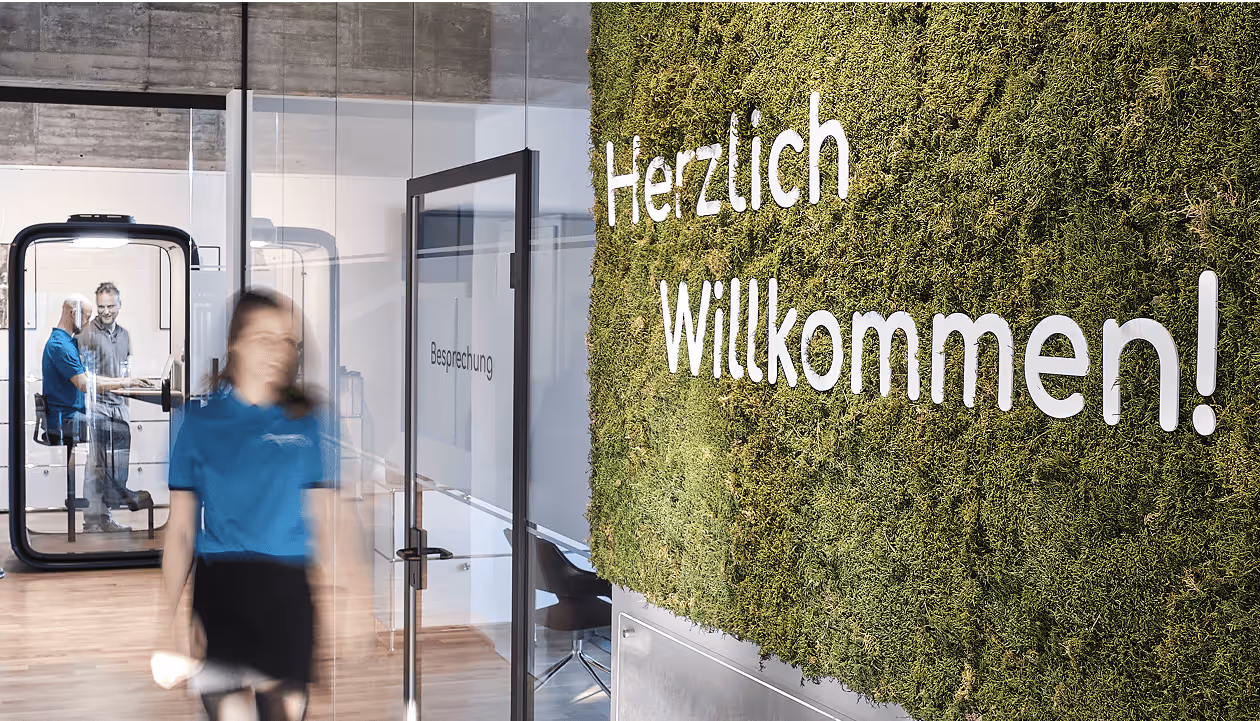 Herzlich willkommen bei prosund – Eingang mit begrüntem Wandlogo und freundlichem Empfangsbereich