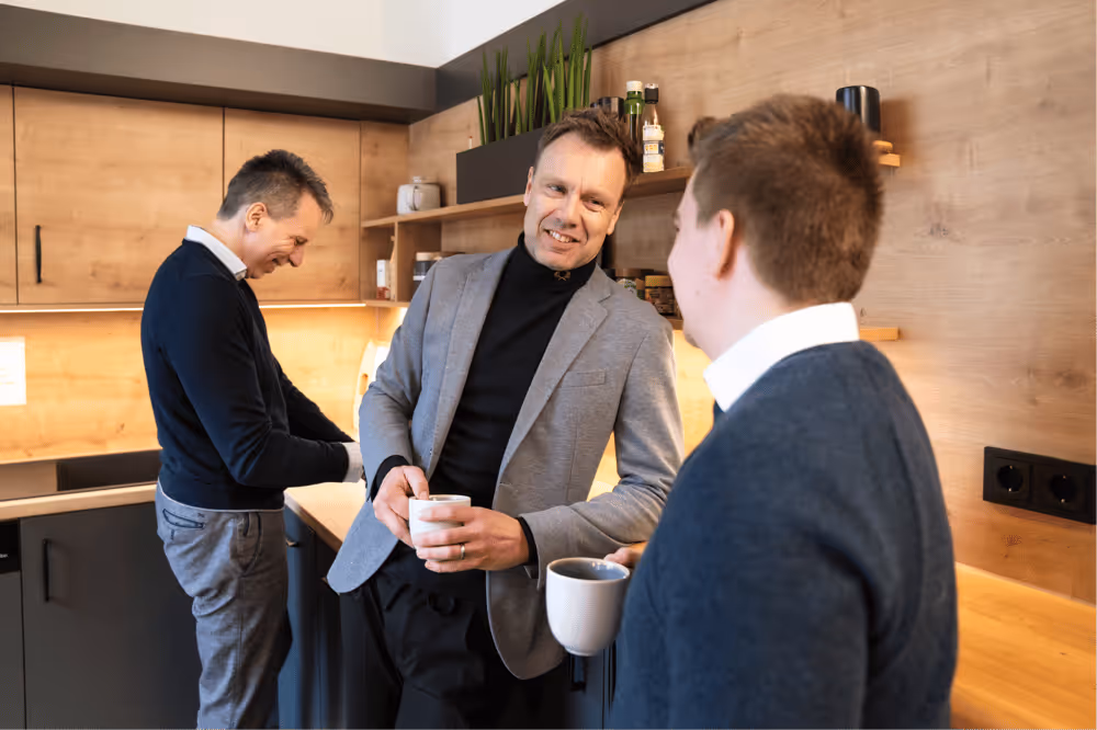 Gespräch zwischen drei Kollegen in der Kaffeeküche