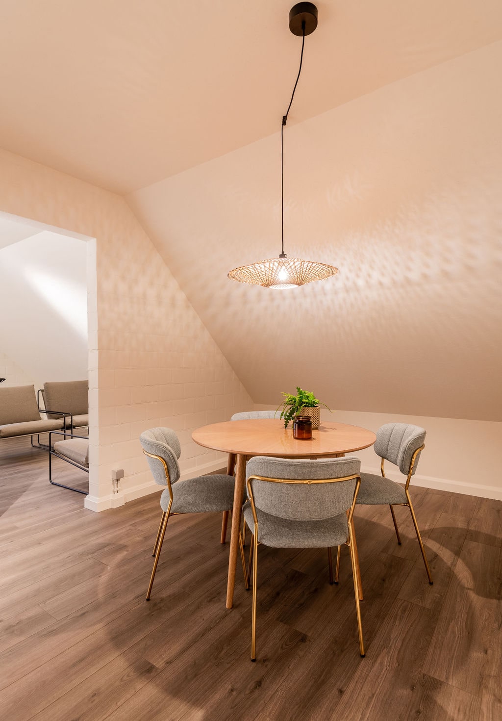 Een zolderkamer ingericht met een tv-meubel en een stijlvolle stoel