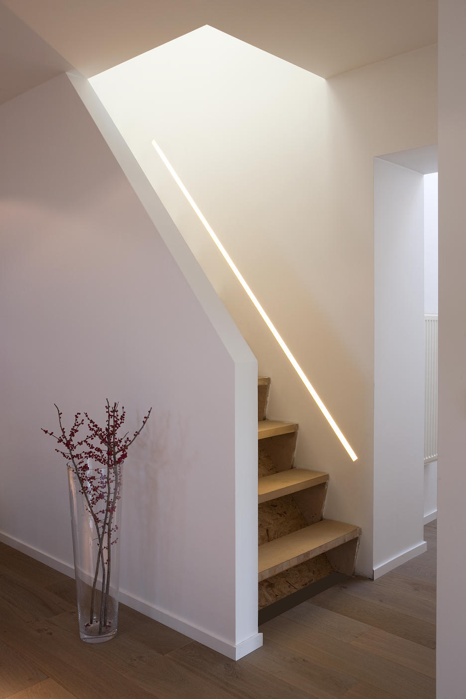 Een trap met lichtstrip ter hoogte van de leuning