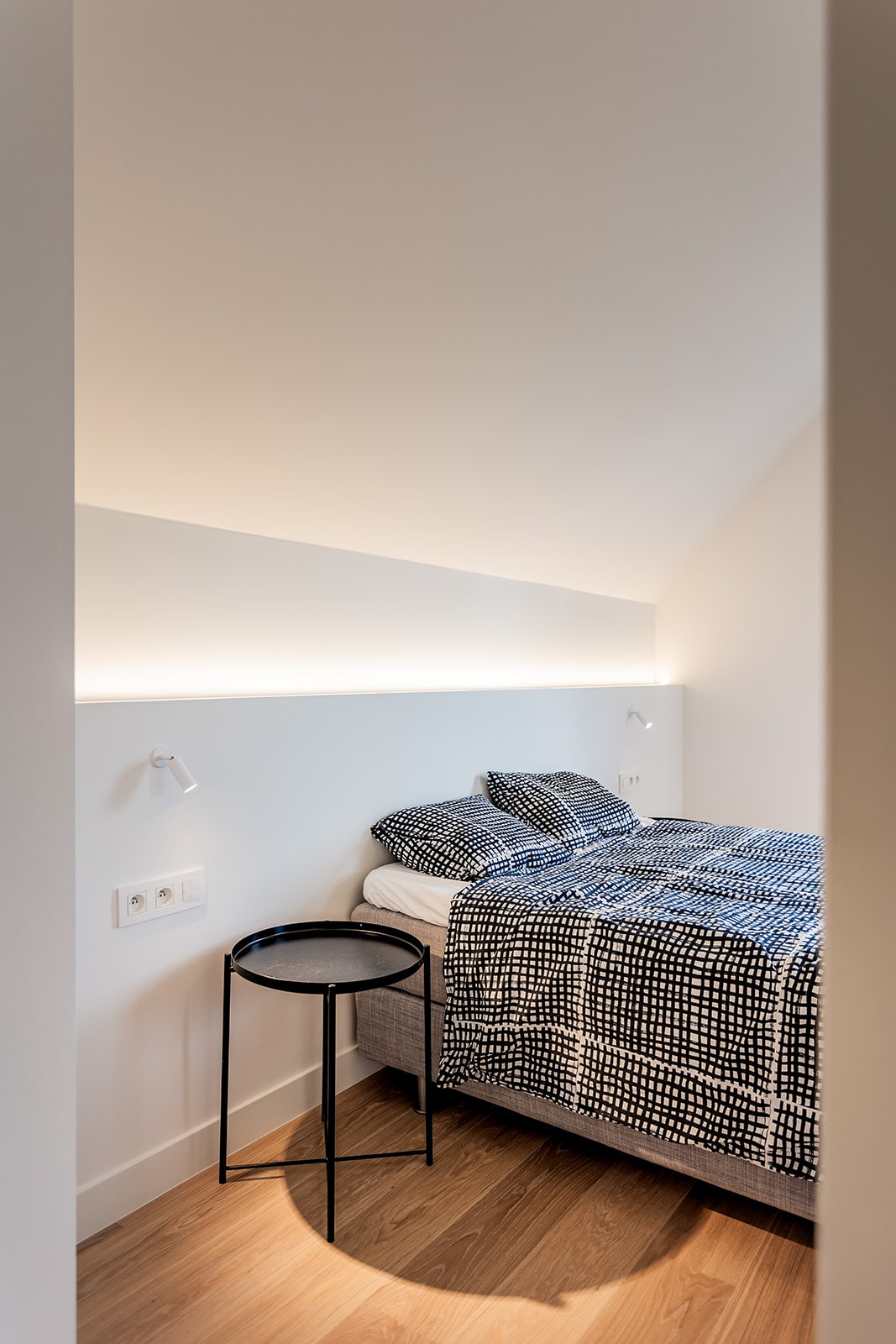 Een bed met daarboven een lichtstrip