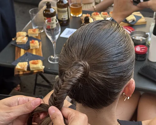 Treccia a spina di pesce su capelli tirati, durante un evento con aperitivo sul tavolo