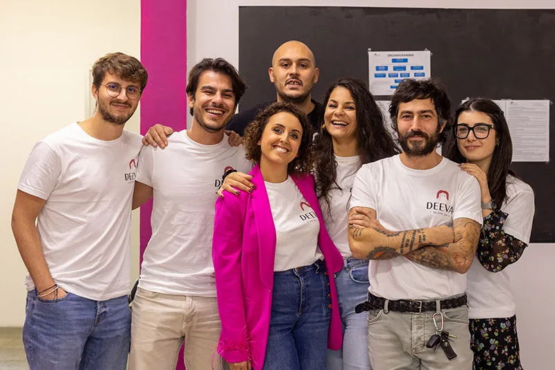 Il team Deeva sorridente in posa con le magliette del marchio