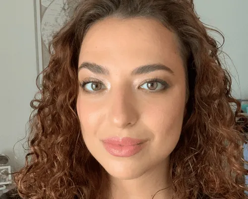 Trucco naturale e luminoso su una ragazza con capelli ricci, ripresa in primo piano