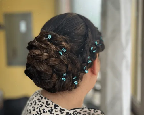 Raccolto intrecciato decorato con piccoli fiori azzurri, visto da dietro