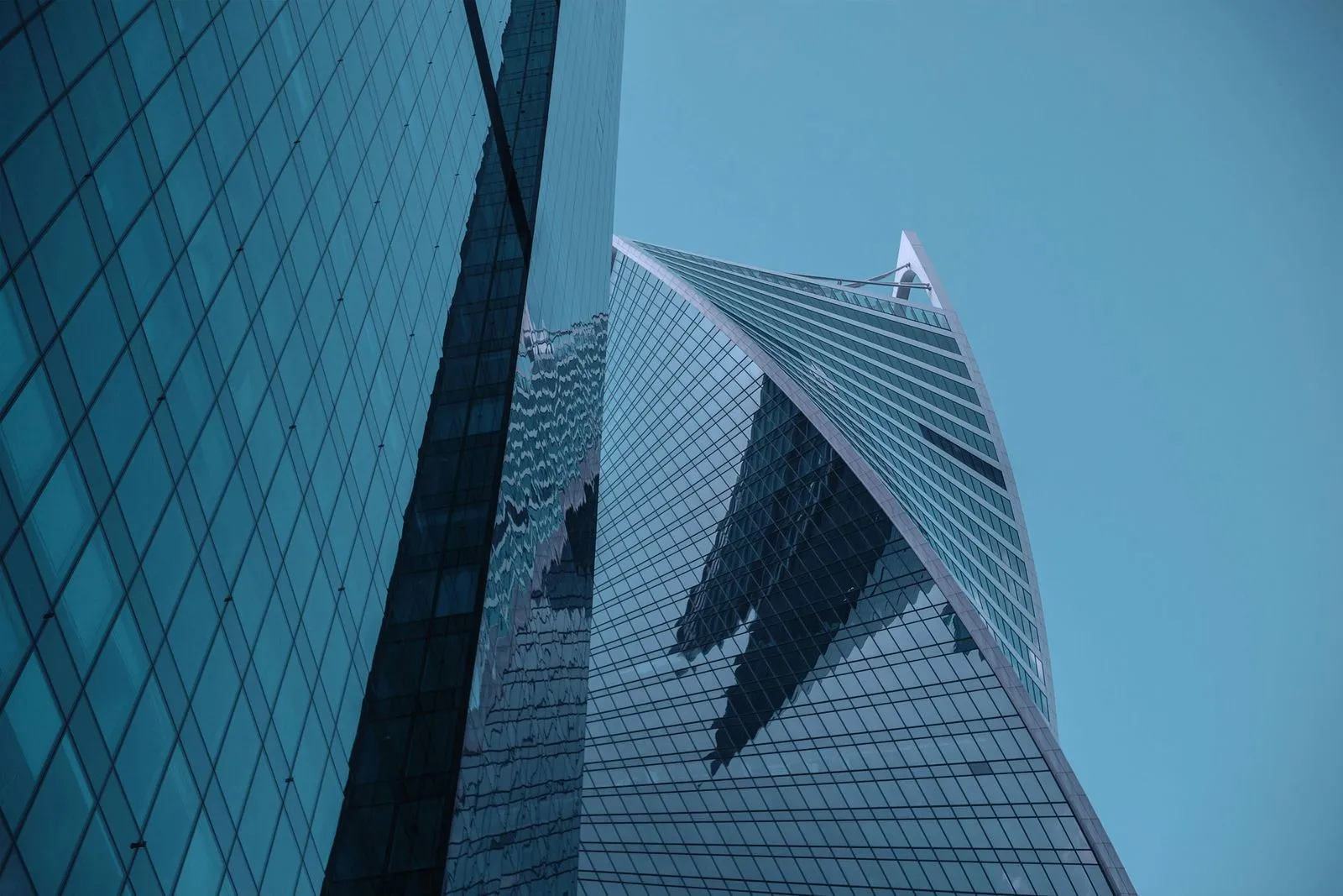 Striking modern skyscraper with a glass exterior, reflecting the cityscape and sky