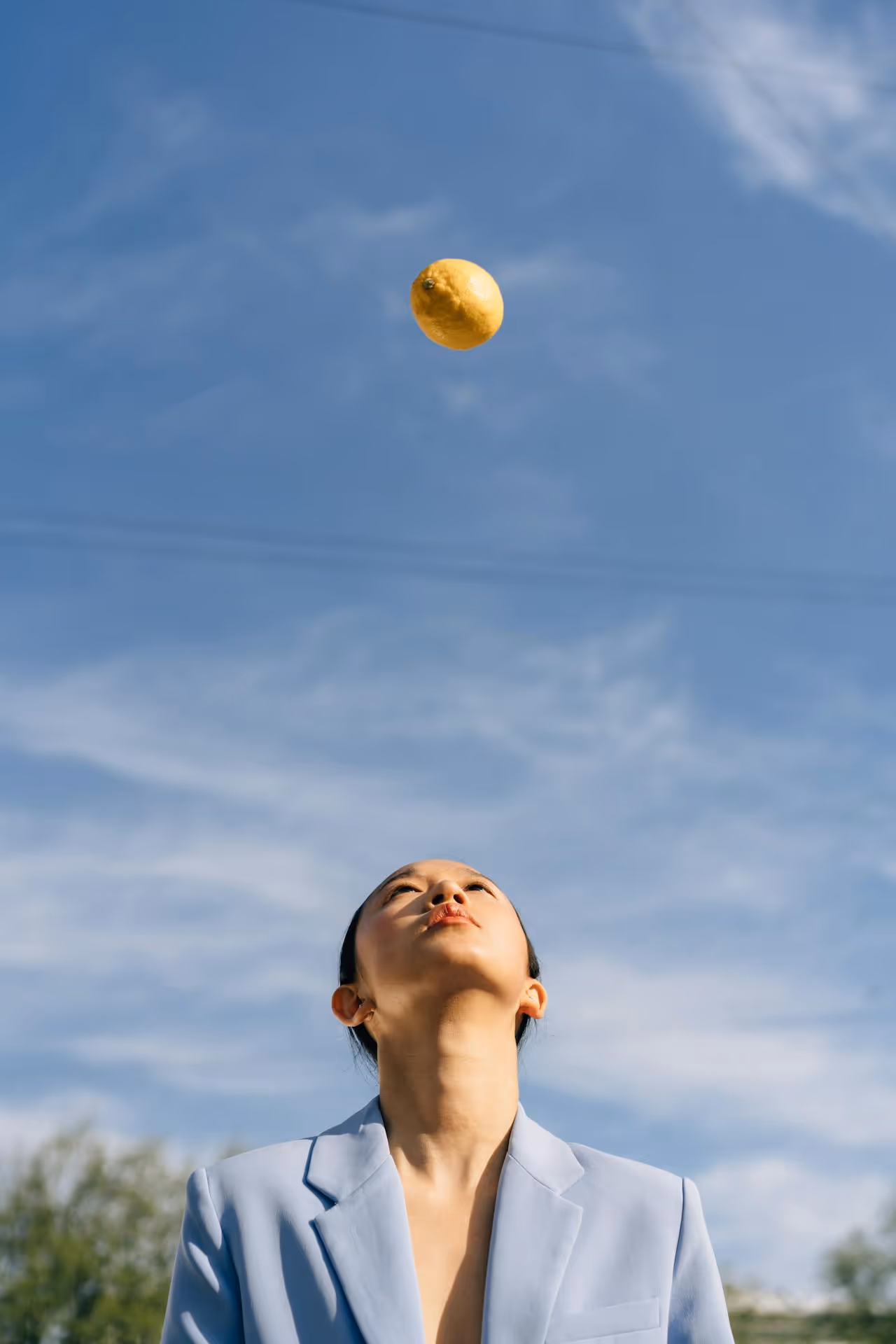 Image of a woman throwing a lemon. 