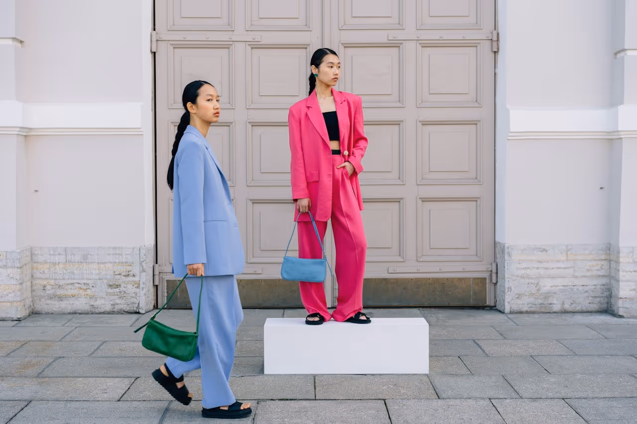 Two models posing with bags.
