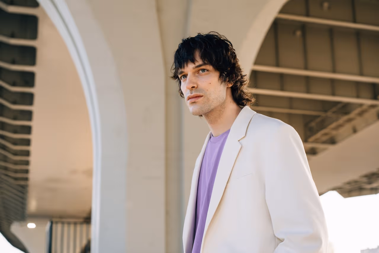 Image of a male model wearinga
 a white suit.