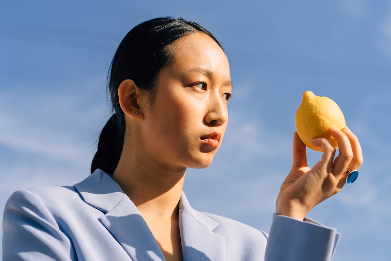 Woman looking at a lemon.
