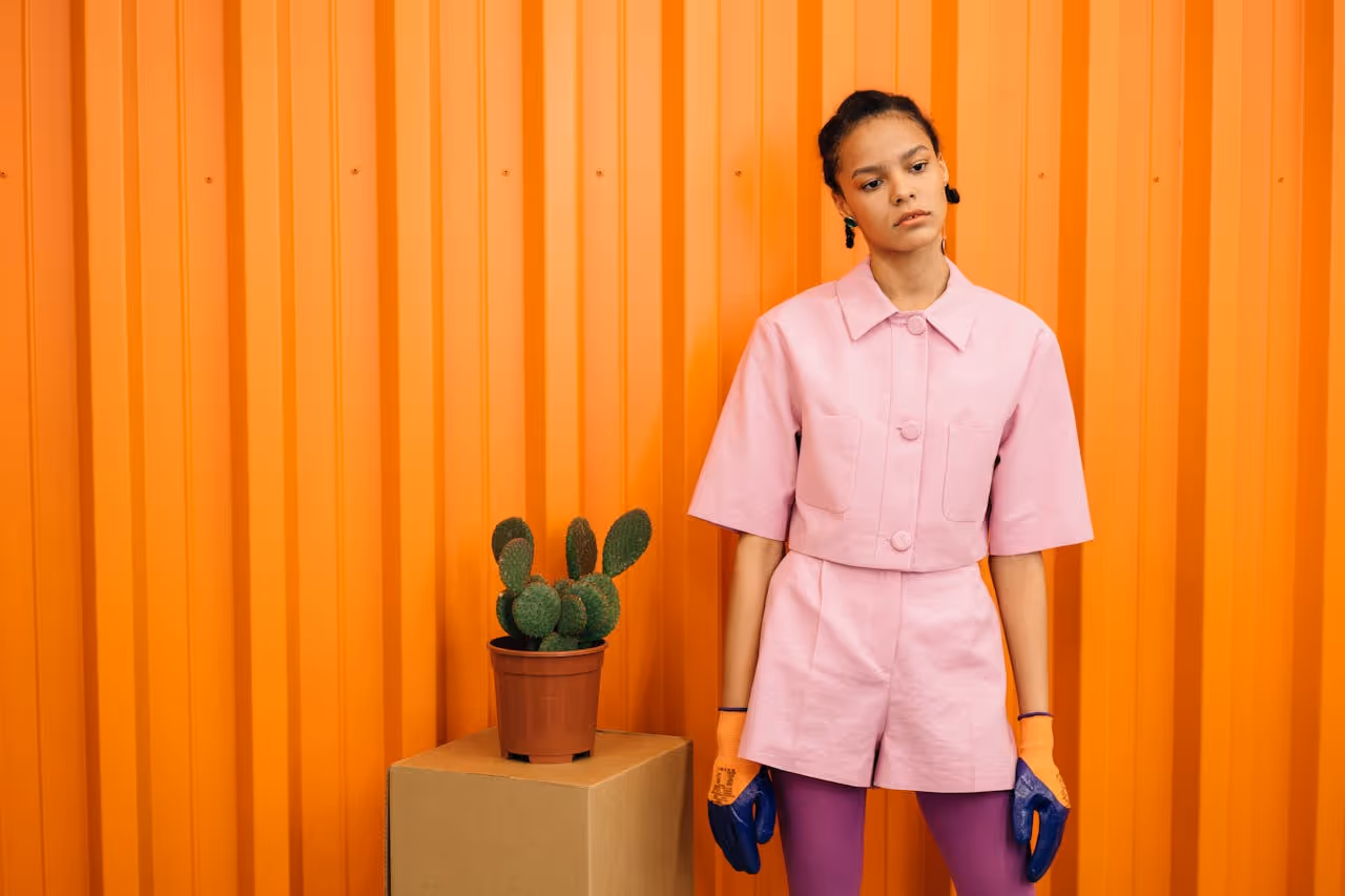 Woman standing next to a plant.