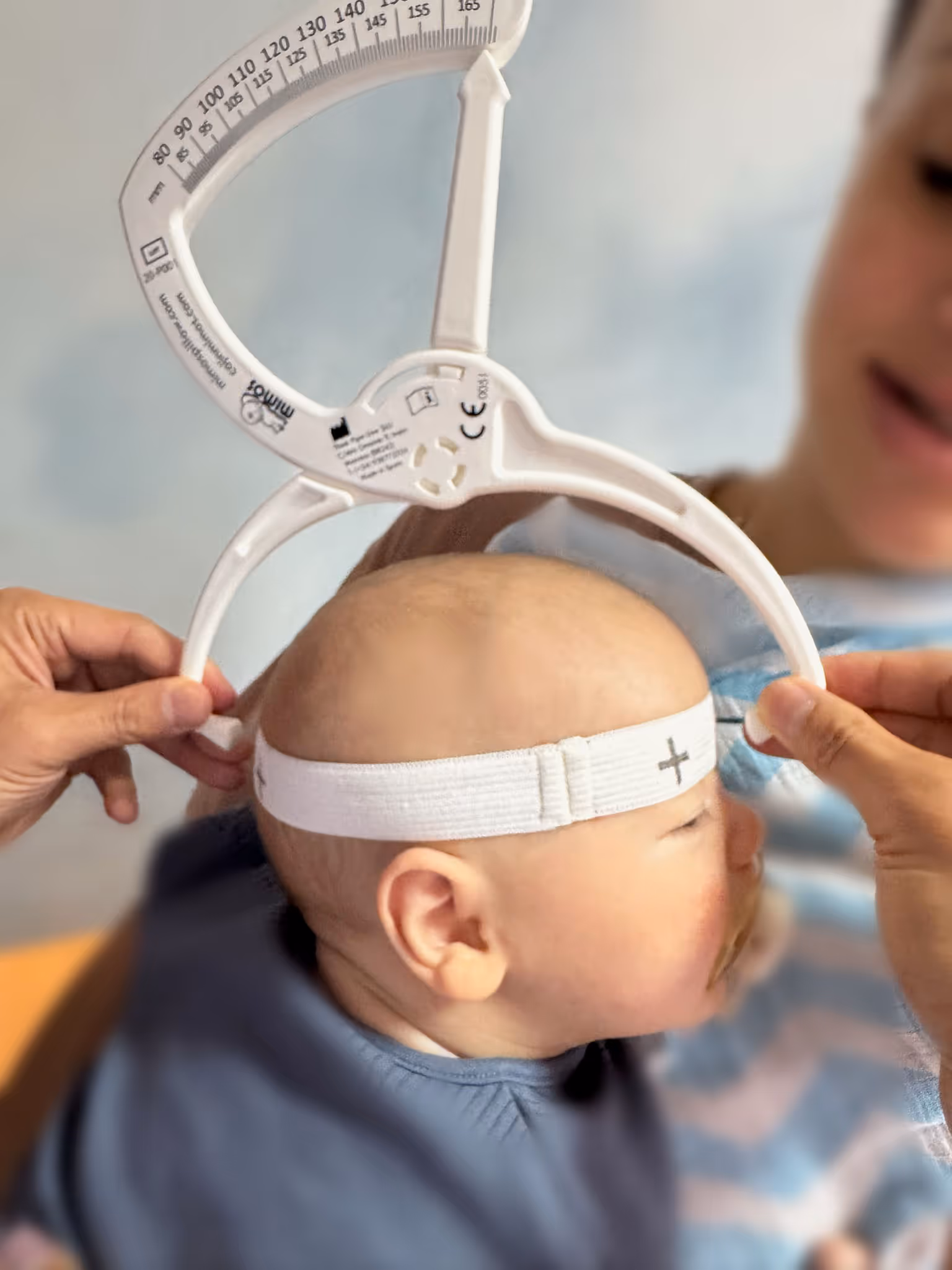 "Paediatric assessment at City Osteopathy showing precise measurement techniques used in the clinic's Happy Melons Program, demonstrating their specialized approach to monitoring infant development and providing targeted osteopathic care for newborns