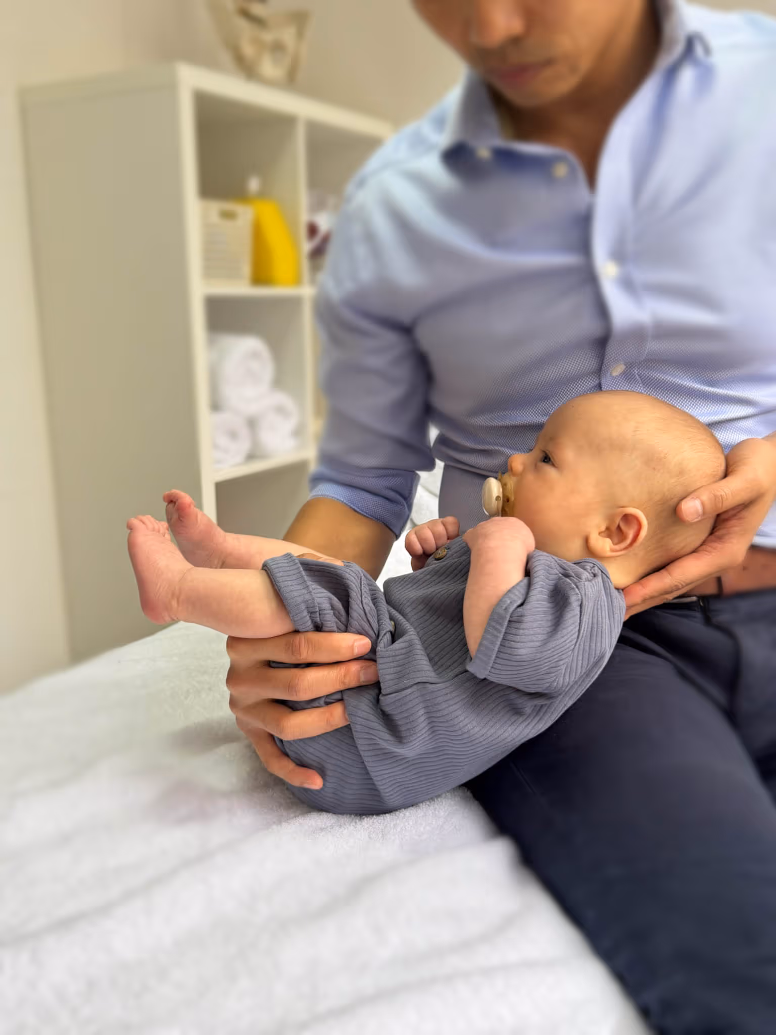 Paediatric osteopathy consultation at City Osteopathy showing gentle assessment of infant as part of the Happy Melons Program, demonstrating the clinic's specialized approach to supporting newborn development and comfort through skilled osteopathic care
