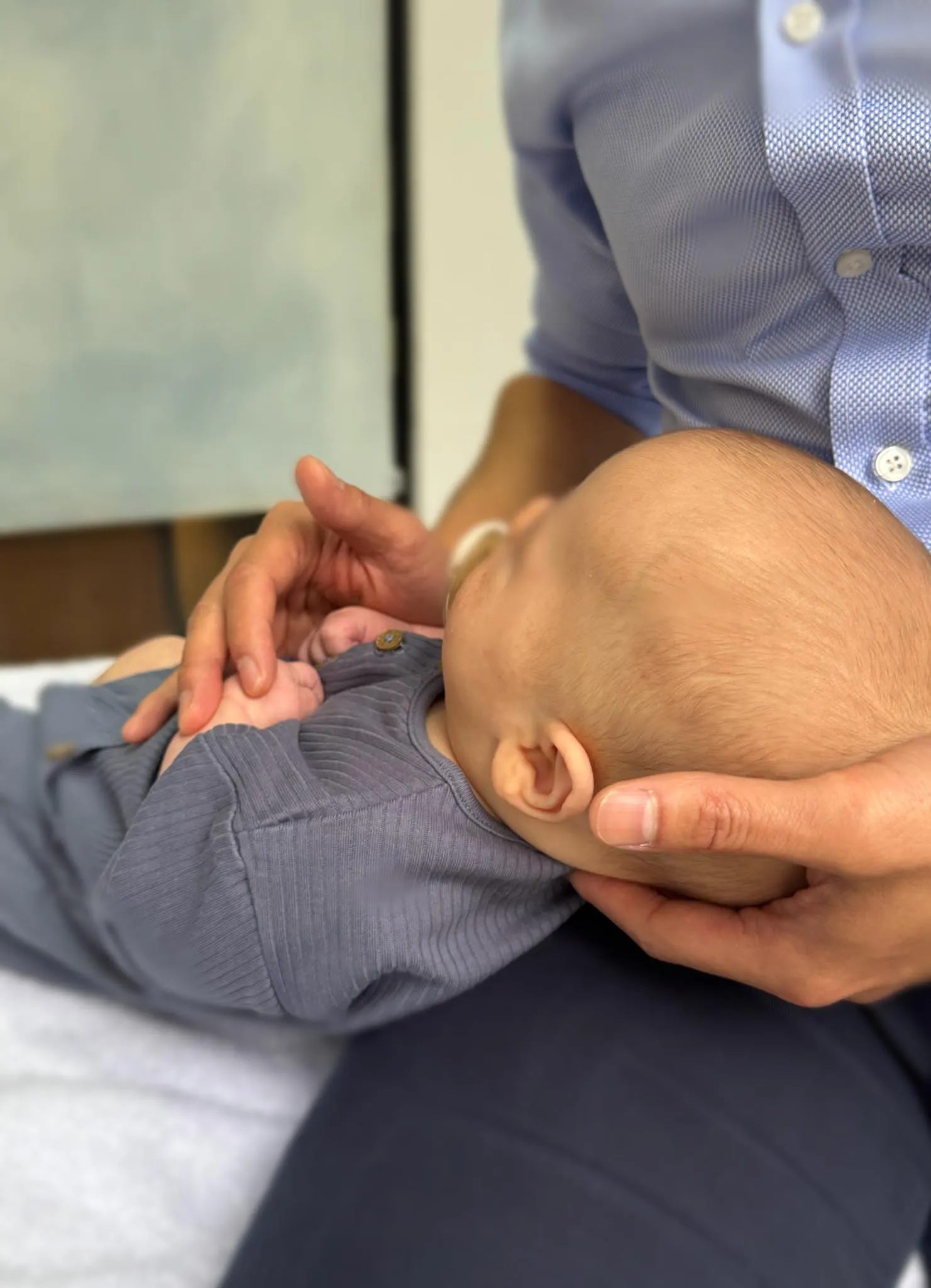 Paediatric osteopathy treatment at City Osteopathy showing practitioner providing gentle cranial care to infant, demonstrating the clinic's specialized osteopathic approach for babies' developmental and comfort needs