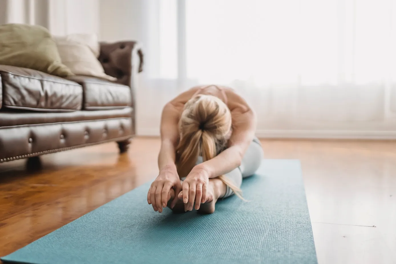 1:1 Pilates session at City Osteopathy showing client performing personalized stretching exercise at home, demonstrating the clinic's tailored movement rehabilitation approach for improved flexibility, mobility and conditioning