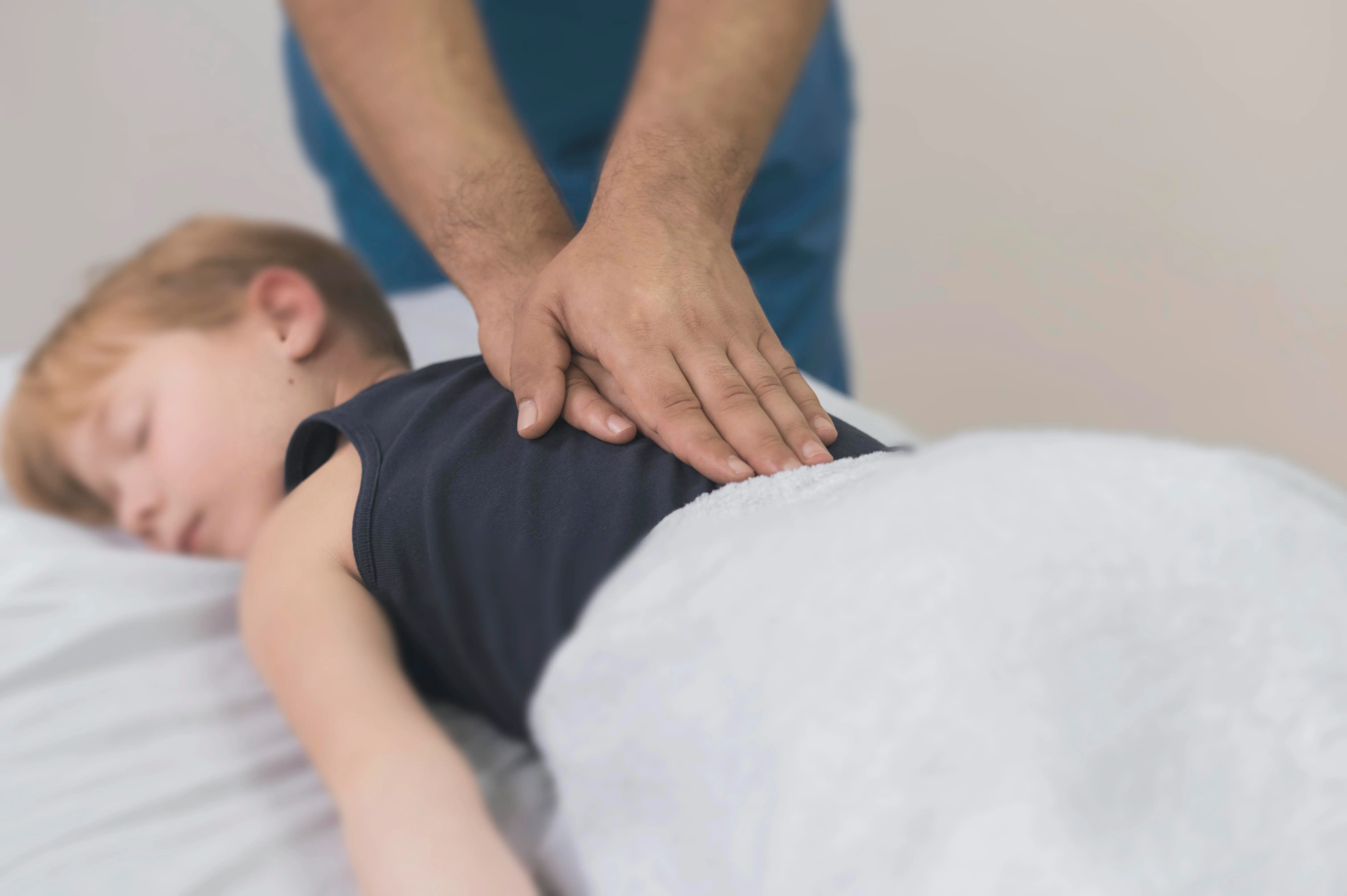 Paediatric osteopathy treatment at City Osteopathy showing practitioner providing gentle spinal care to child patient, demonstrating the clinic's specialized osteopathic approach for children's developmental and postural needs