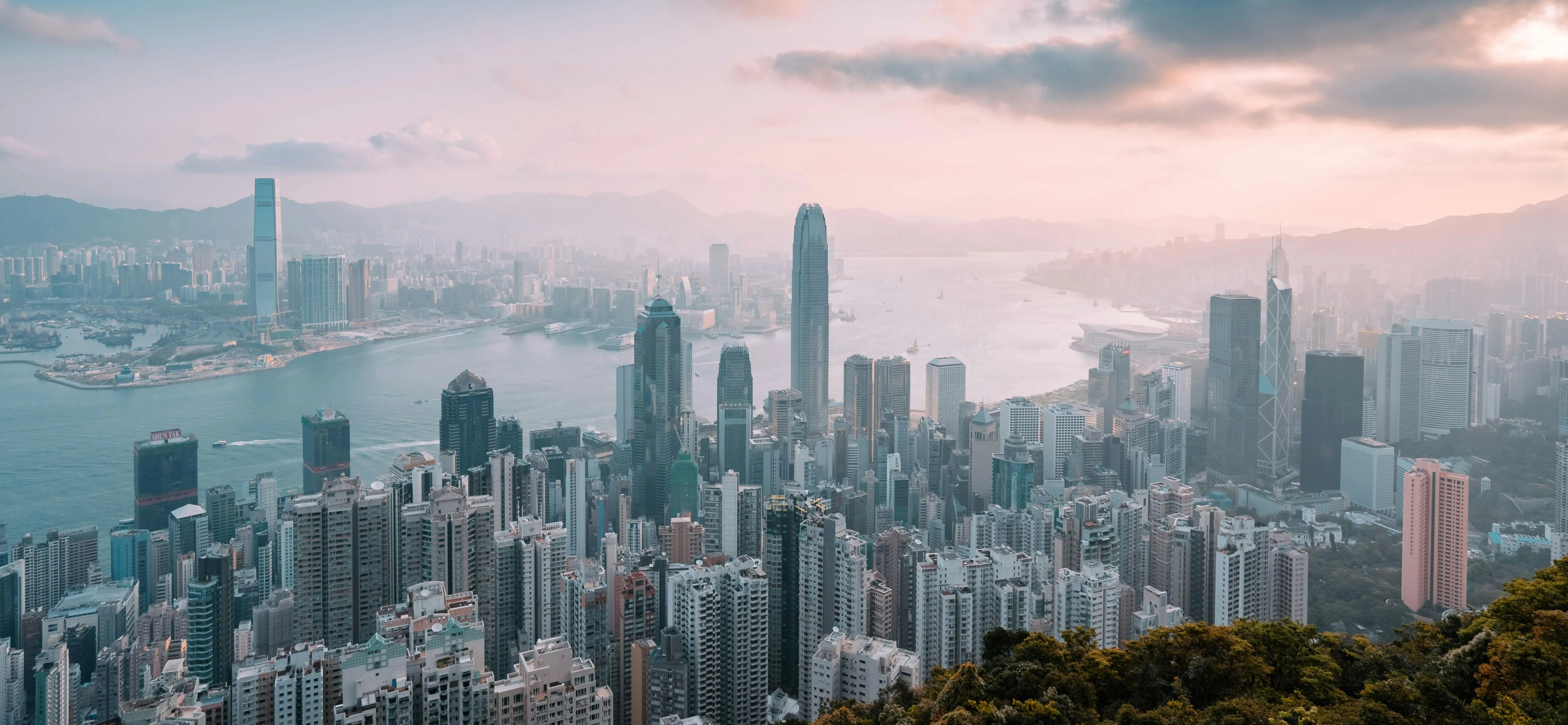 Panoramic view of Hong Kong skyline and Victoria Harbour at sunset, showcasing the city where City Osteopathy provides integrated healthcare services to local families and patients