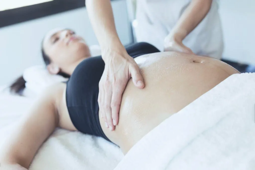 Osteopathic treatment session at City Osteopathy showing hands-on manual therapy technique being performed on patient's abdomen, demonstrating the clinic's non-invasive rehabilitative care approach