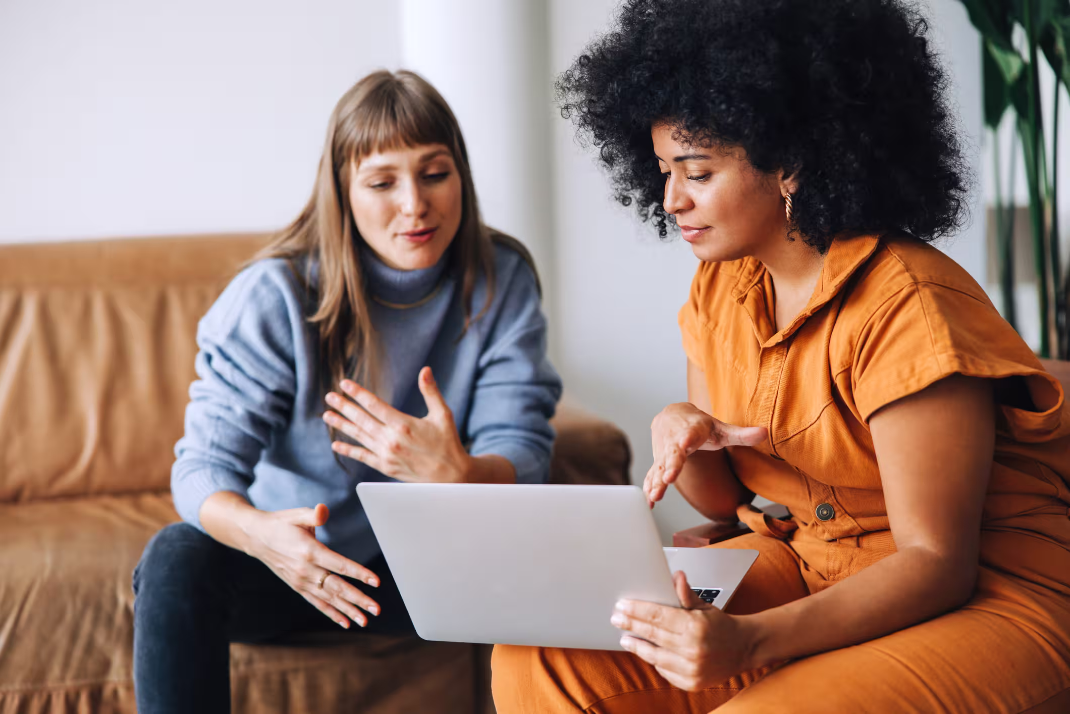 A manager and employee talking in front of a laptop.
