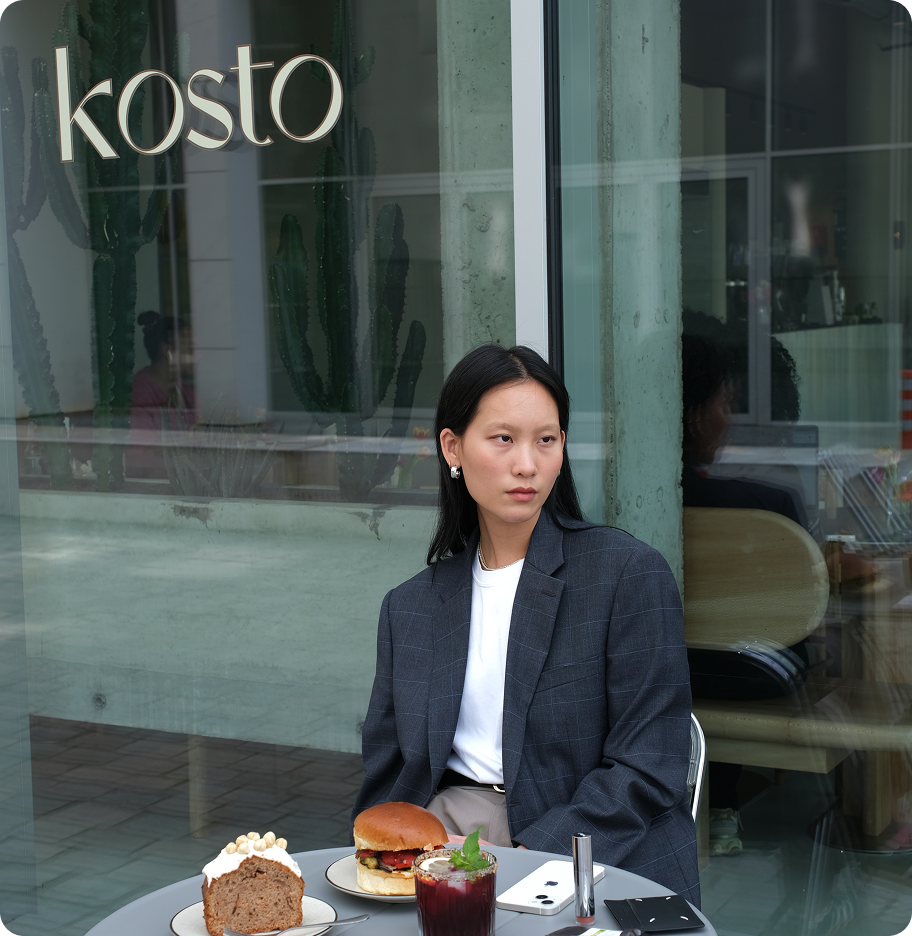Breakfast moment of a women in front of Kosto’s glass façade.