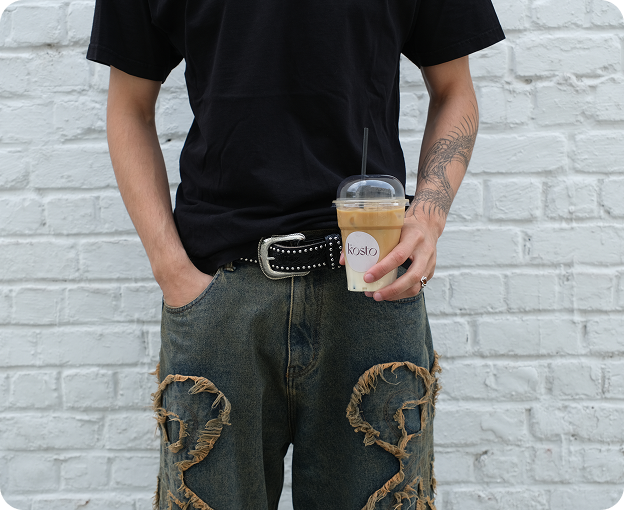 Street-style shot with iced coffee and embroidered trousers.