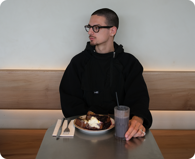 Moment of pause: man enjoying cake and coffee at Kosto’s cozy corner.