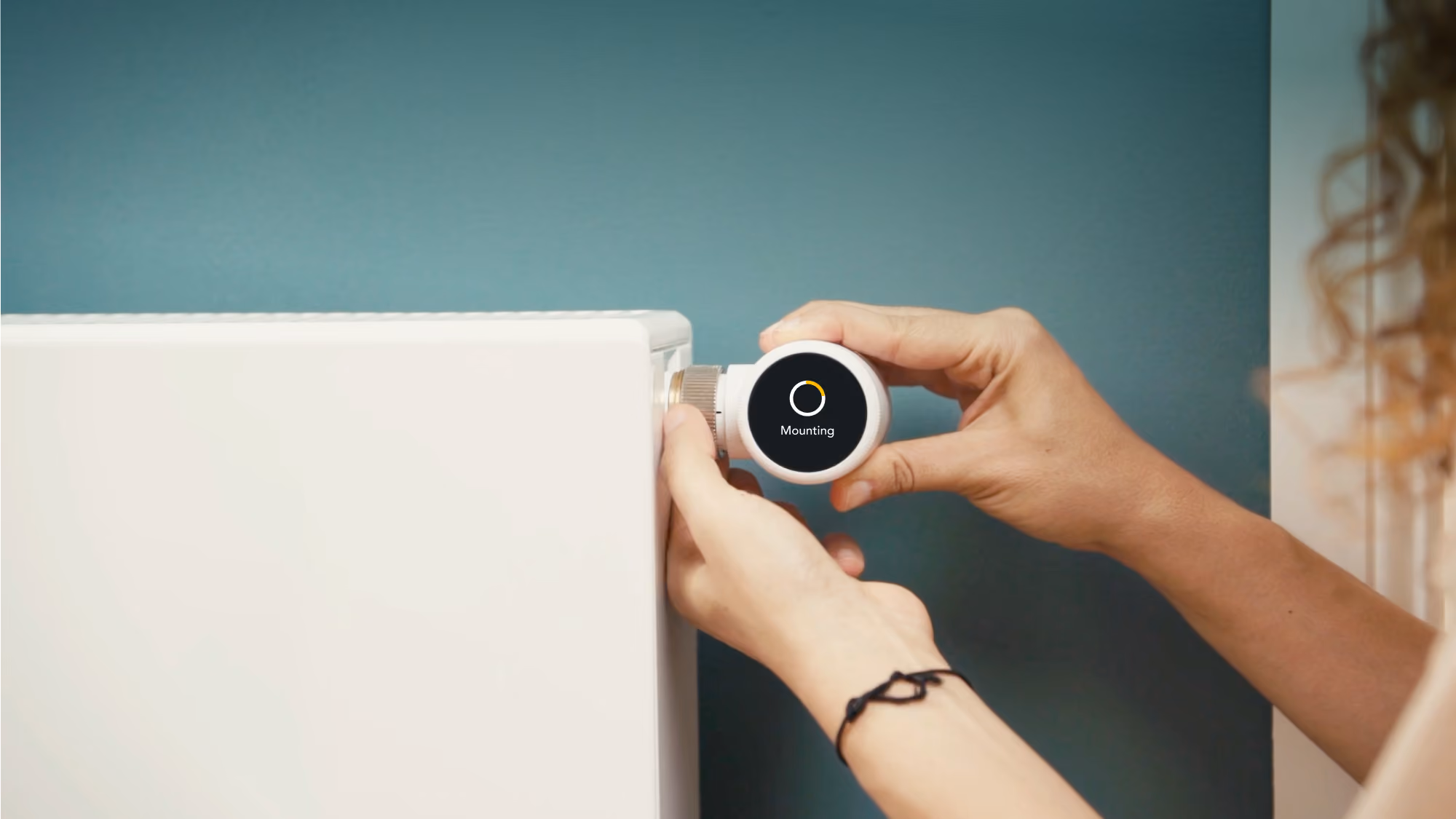 A person fitting a Smart Radiator Thermostat X to a radiator.