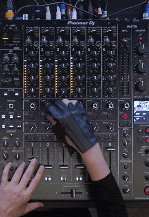 Close-up of a DJ adjusting faders and knobs on a Pioneer DJ mixer. The DJ wears a performance glove while mixing live